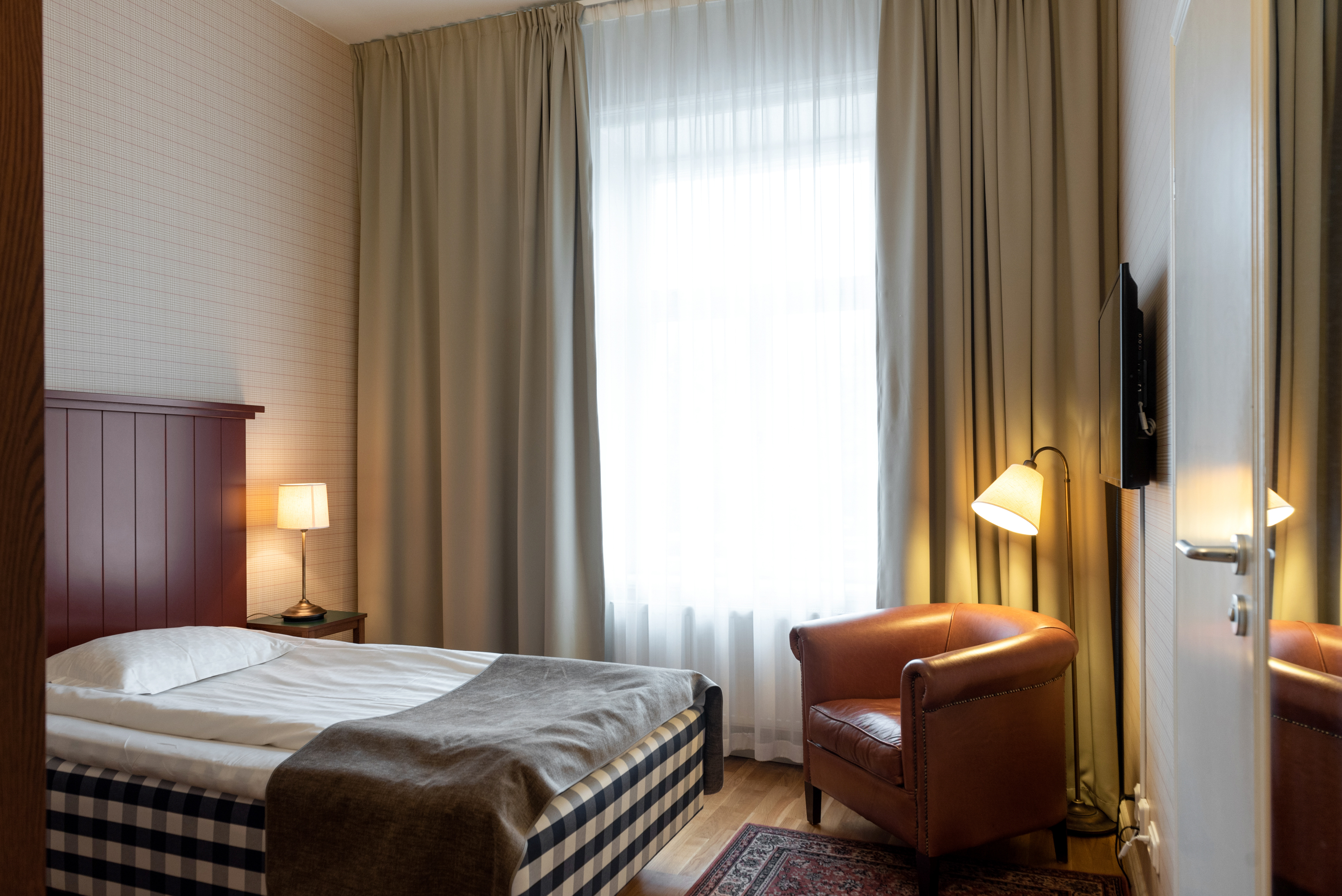 Hotel room with Hästens bed, leather armchair and window
