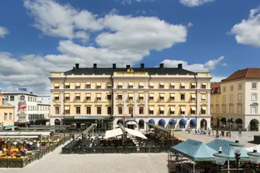 A huge yellow building with outdoor seating