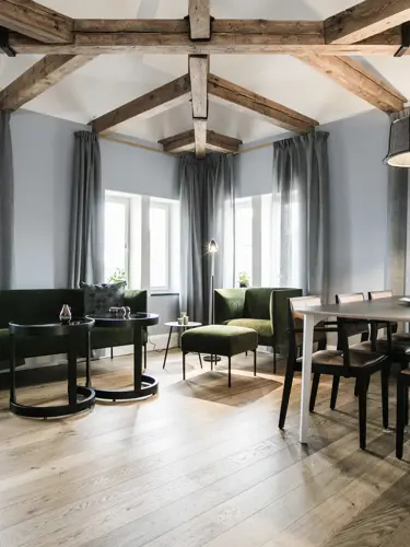 Hotellsvit med soffa, matbord och takbalkar