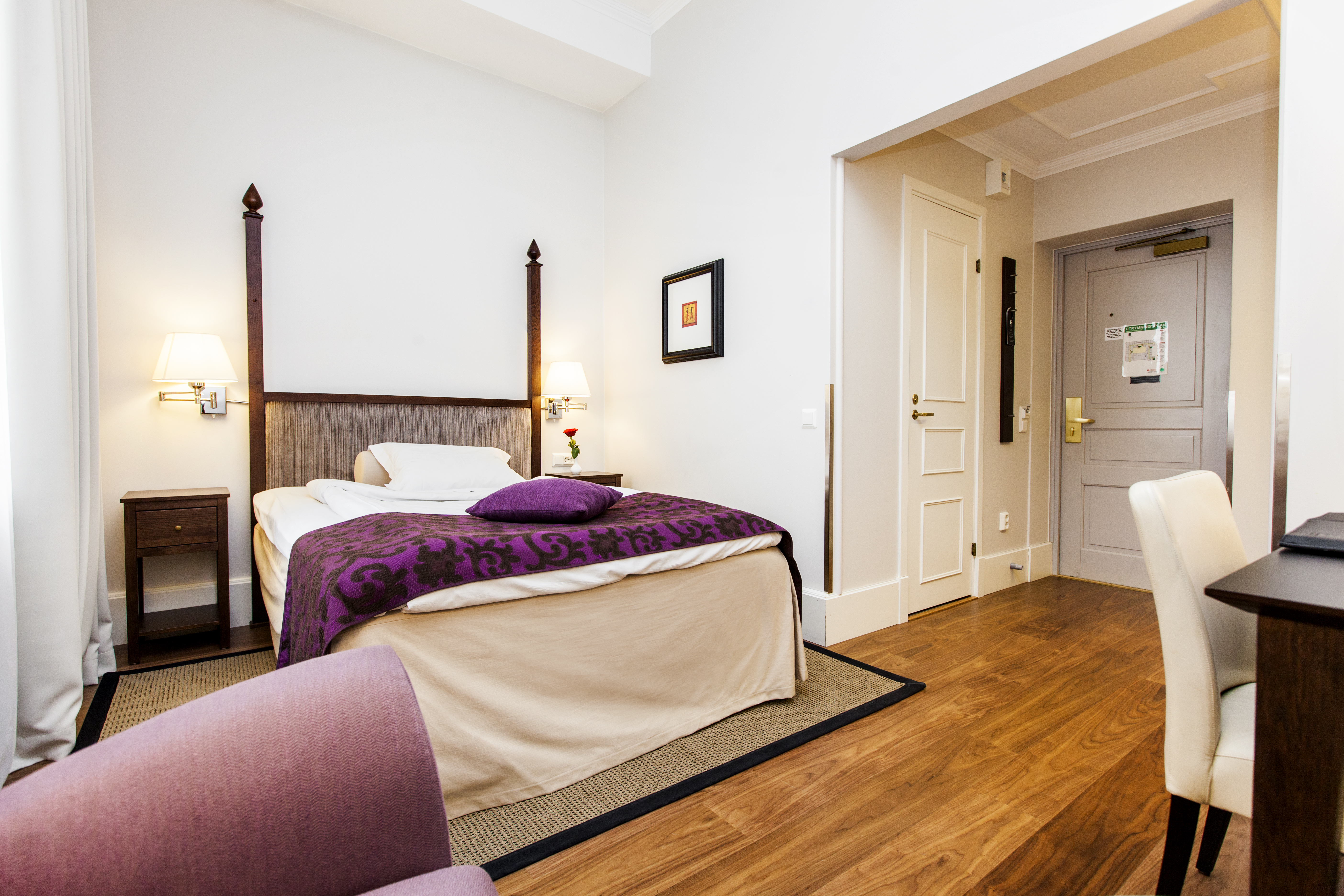 Bright hotel room with desk, single bed and blackboard