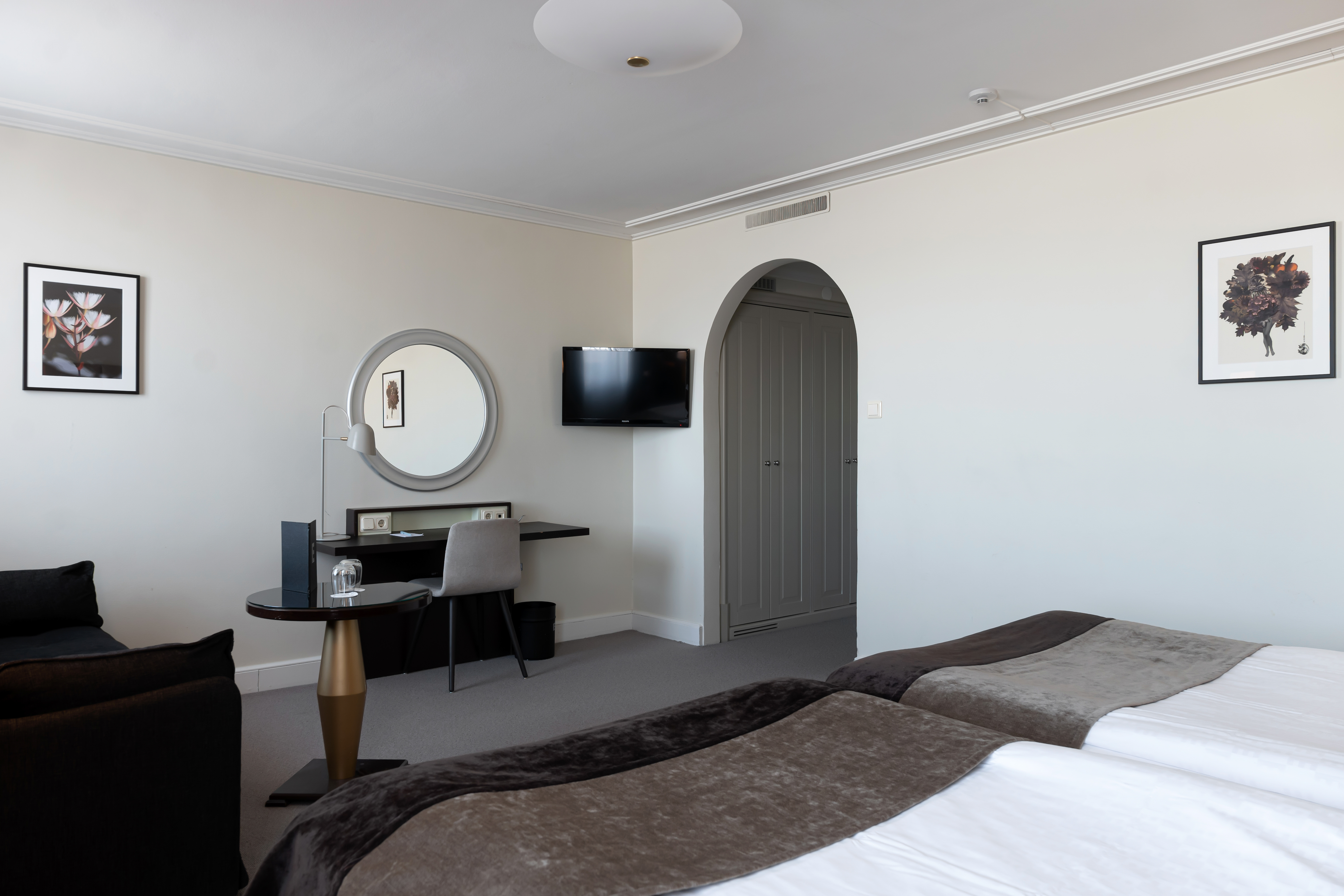Bright hotel room with vault, desk and round mirror