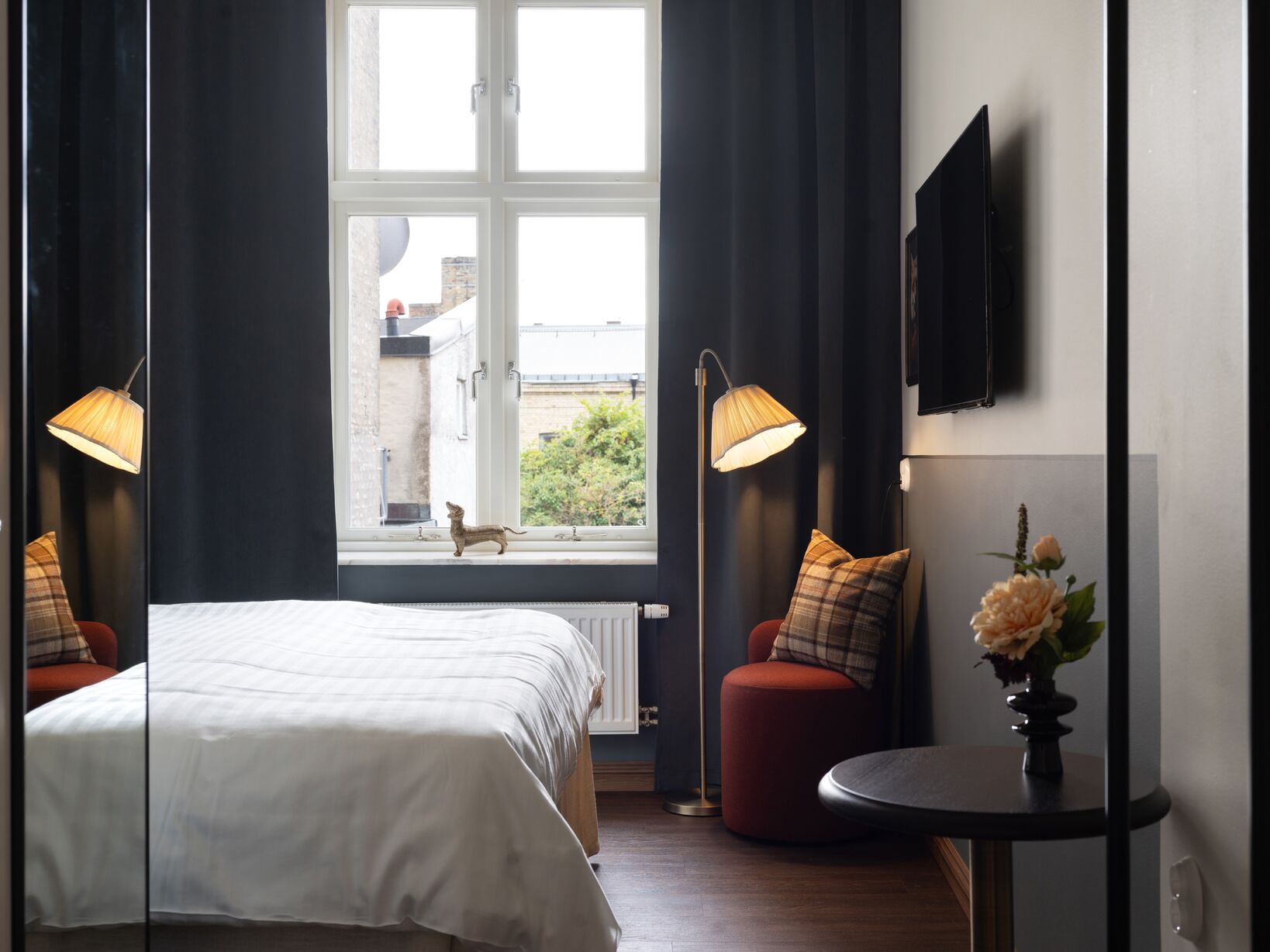 Bright hotel room with bed, orange headboard and blackboard