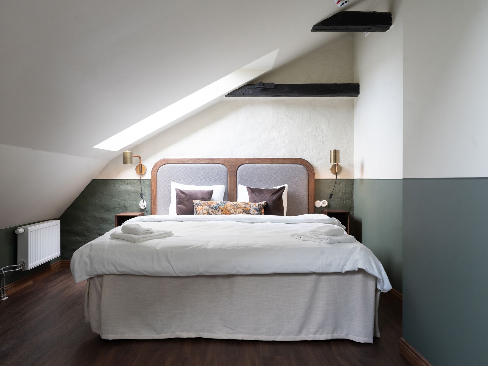 Bright hotel room with bed, wardrobe and bedside lamps