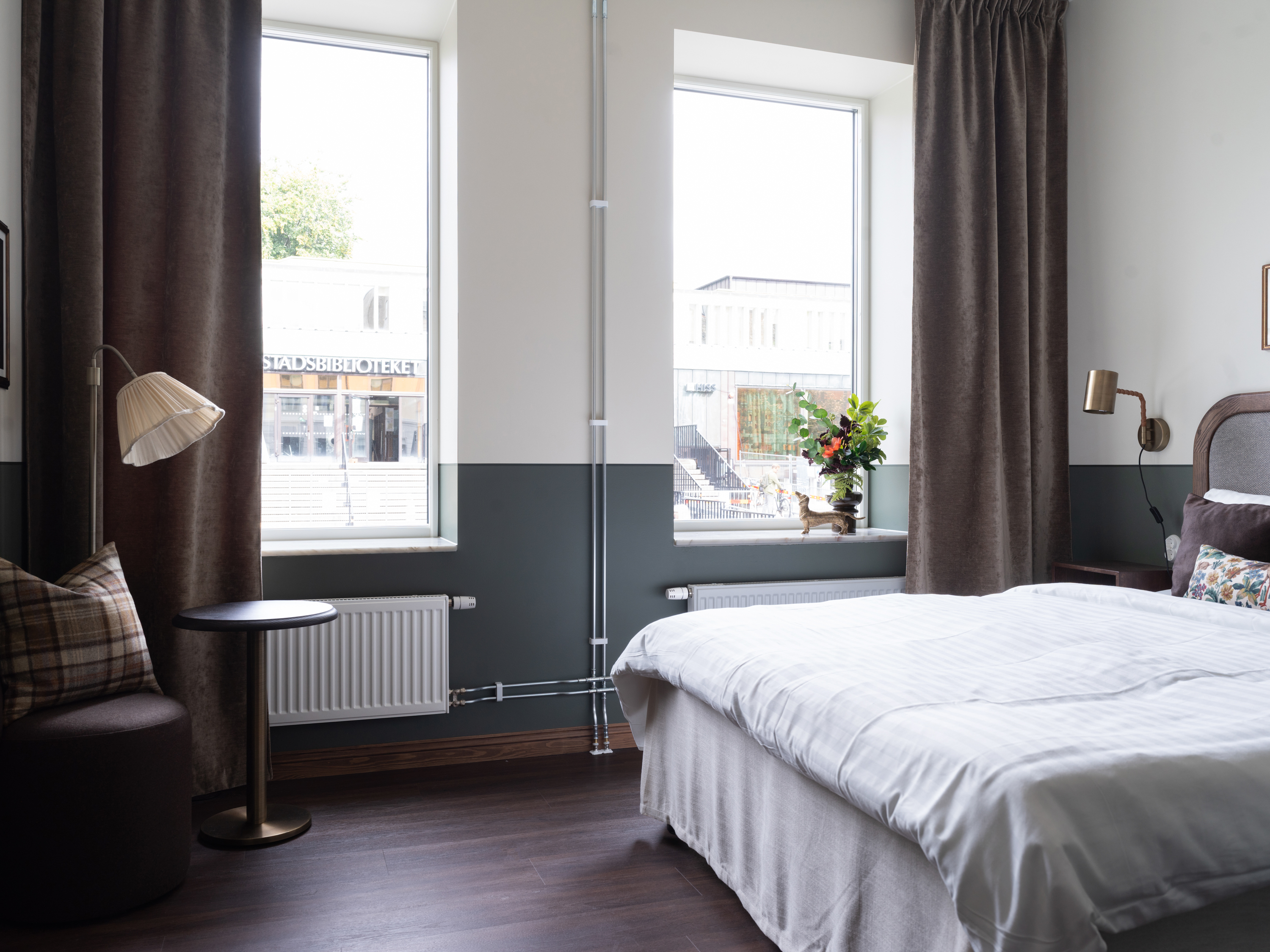 Mysigt hotellrum med säng, fönster och skrivbord