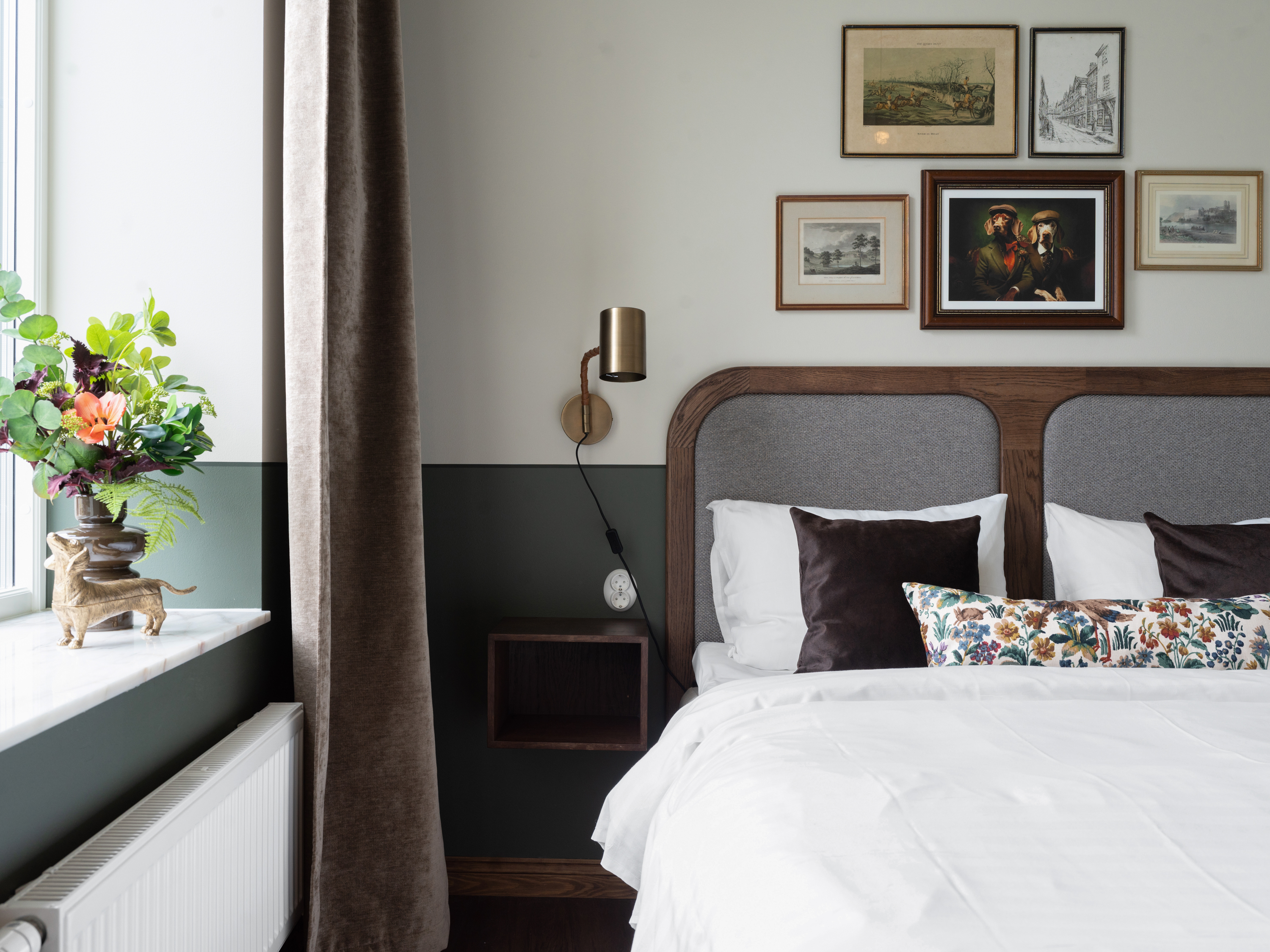 Hotellrum med säng, vit sänggavel och prickiga kuddar