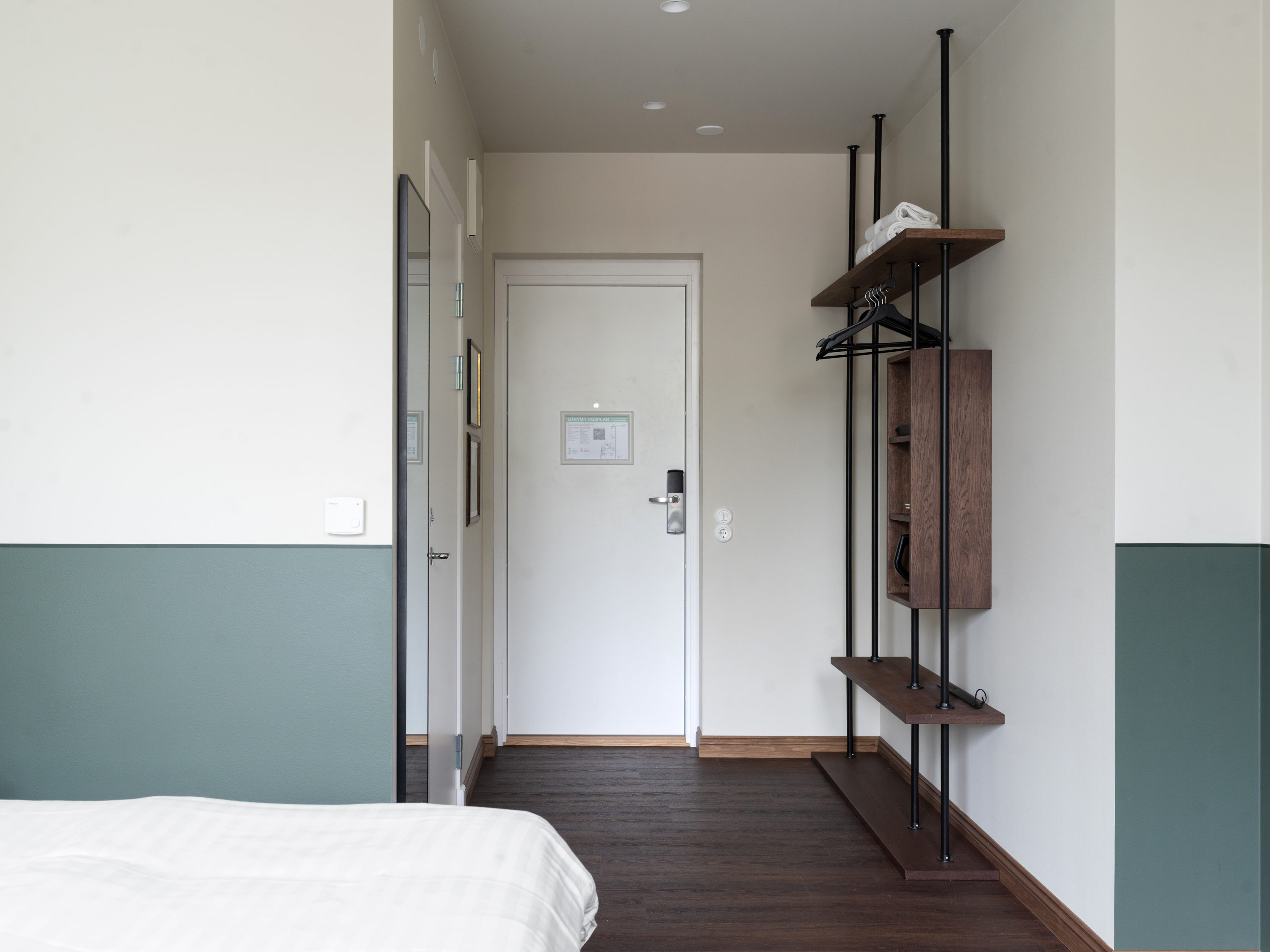 Mysigt hotellrum med säng, orange sänggavel och skrivbord