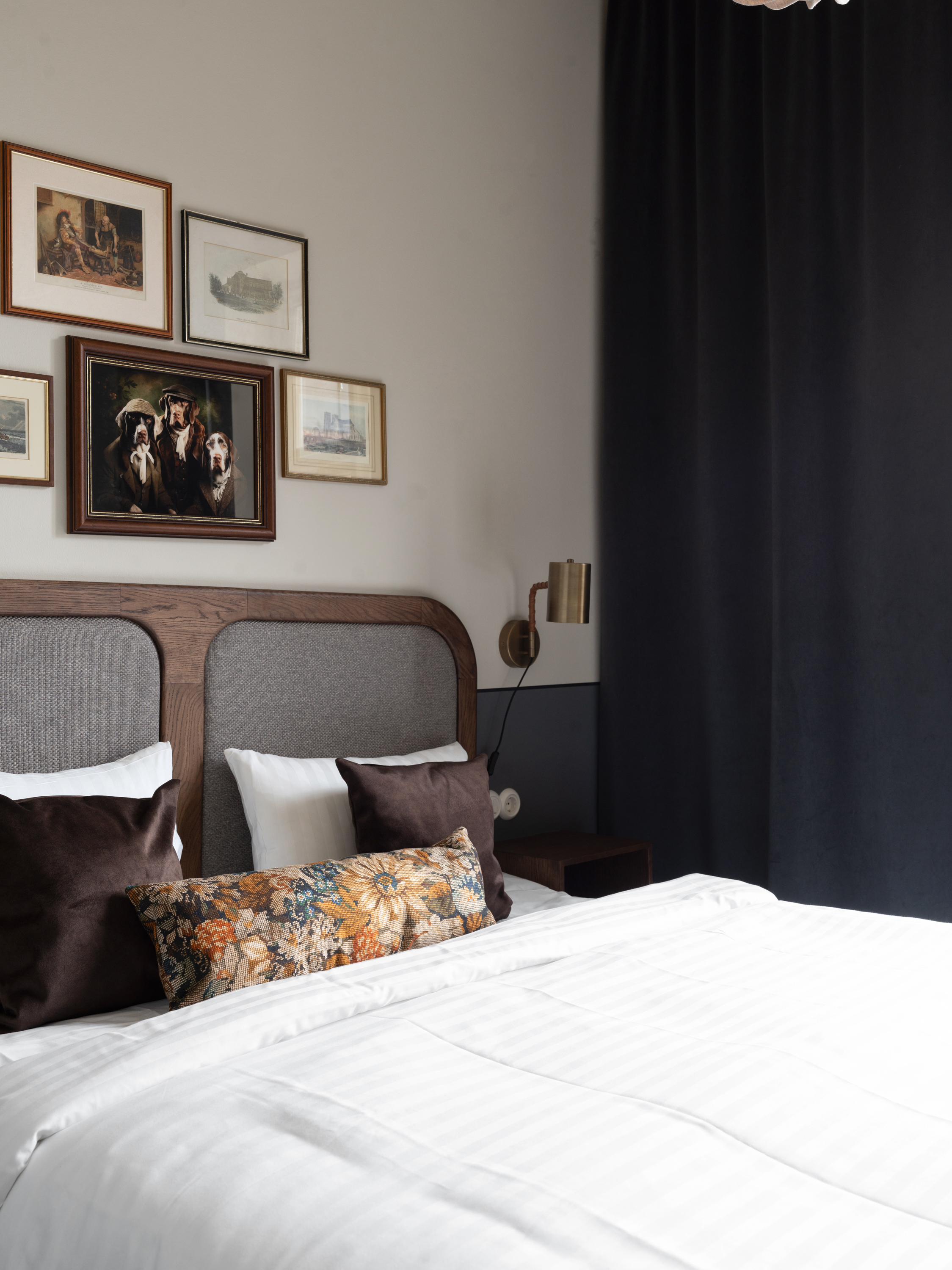 Hotellrum med säng, orange sänggavel och prickiga kuddar