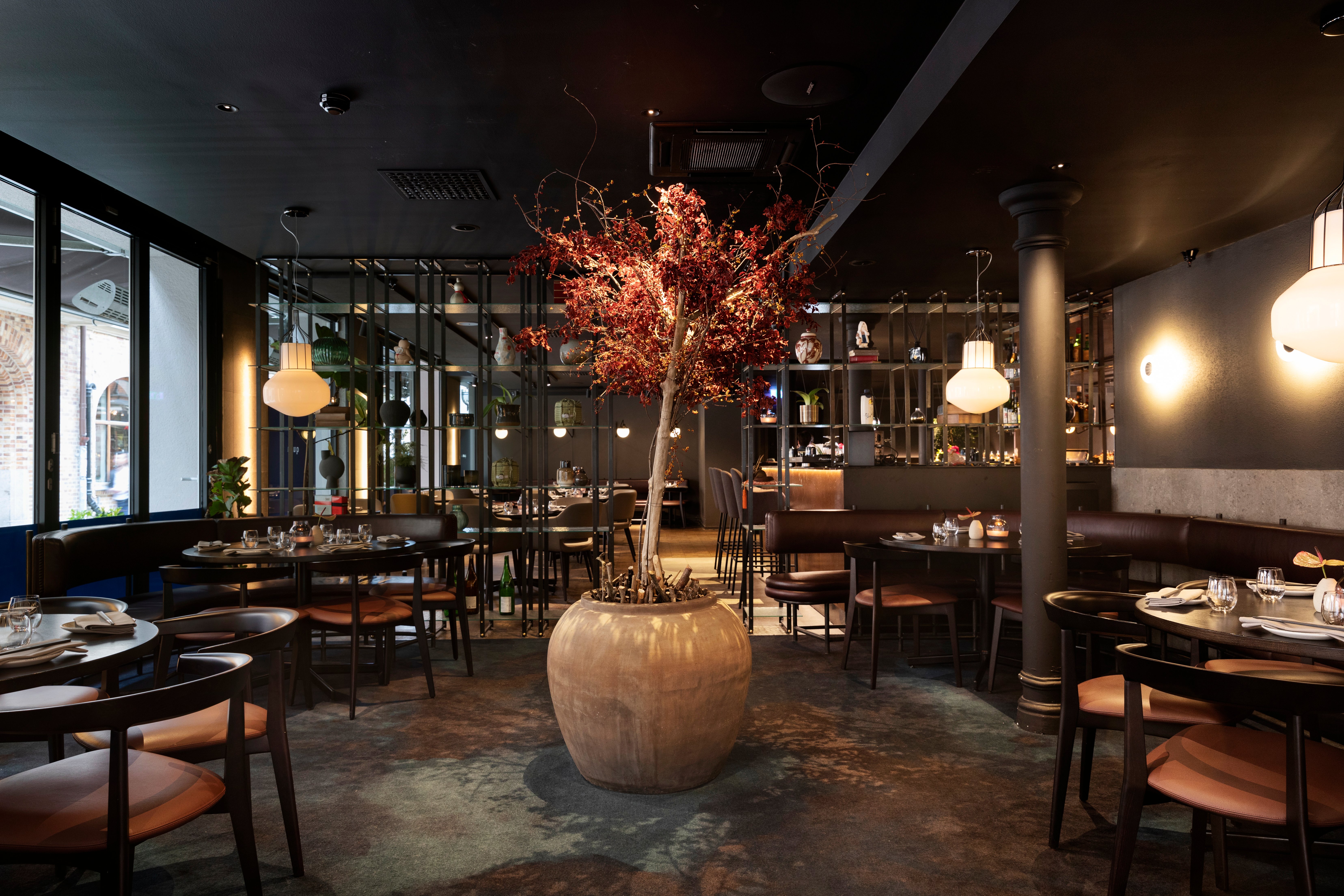 Restaurant environment with a large red tree in the middle