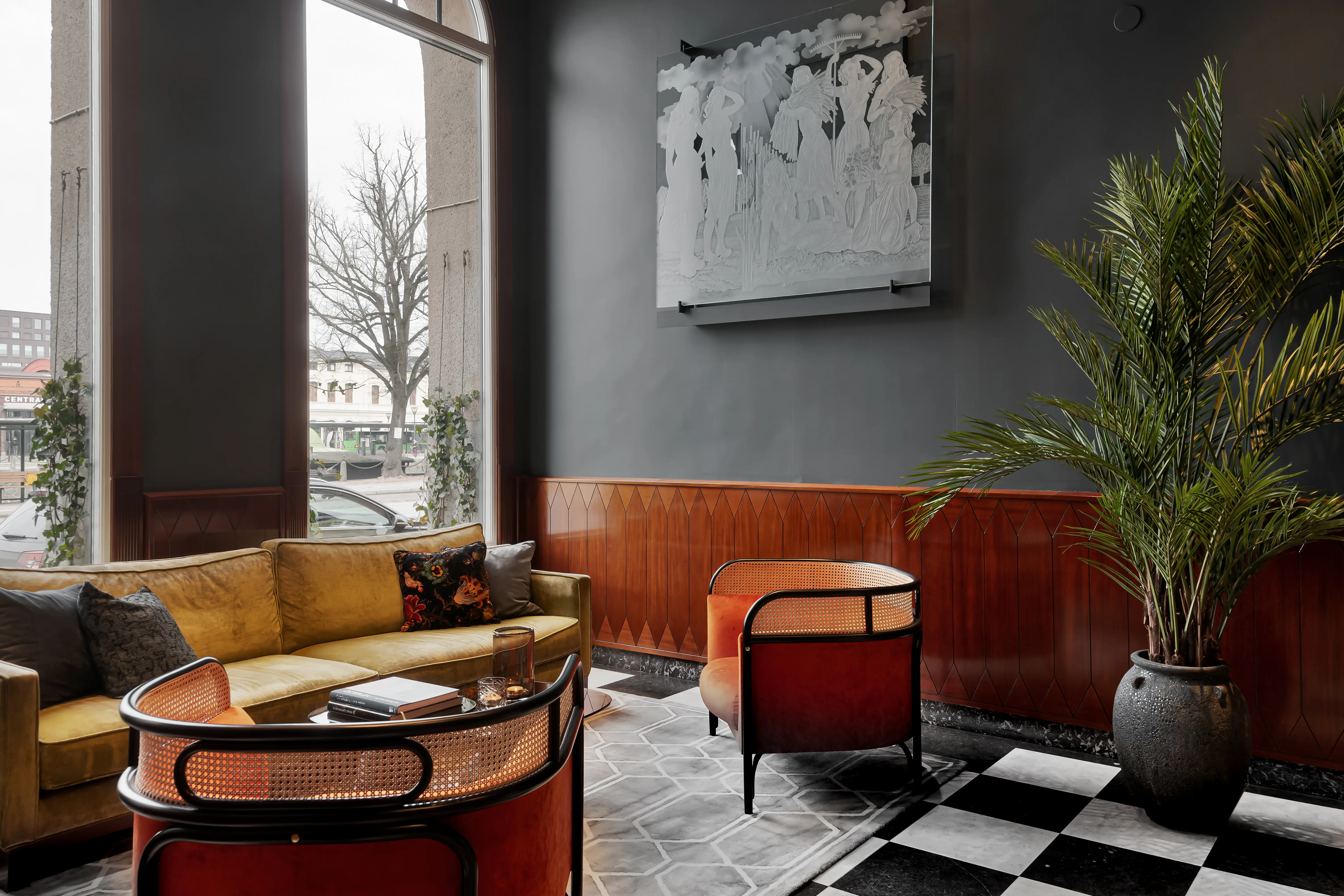 Hotellobby med loungegrupp, krukväxter och tavlor