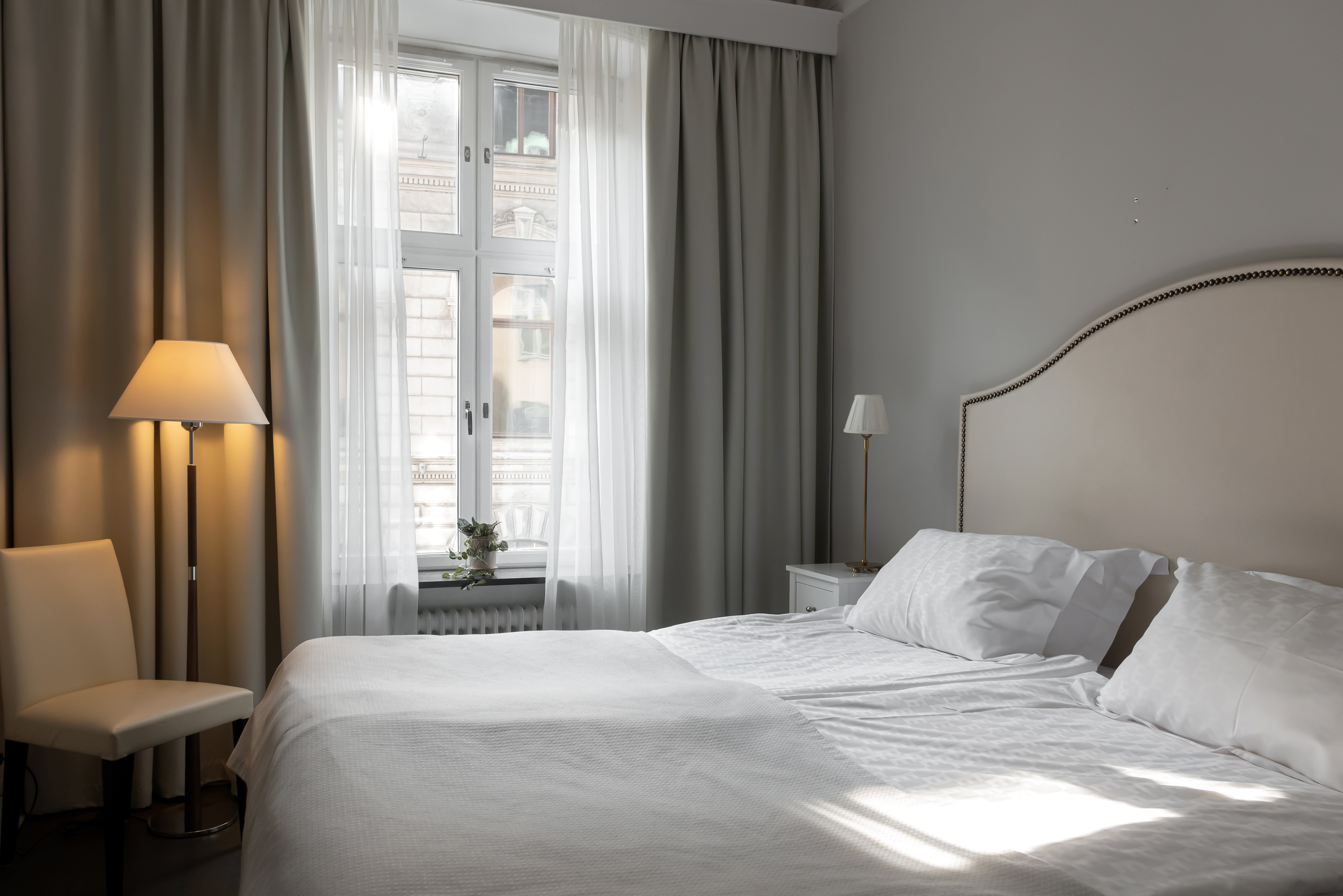 Cozy hotel room with double bed, floor lamp and window