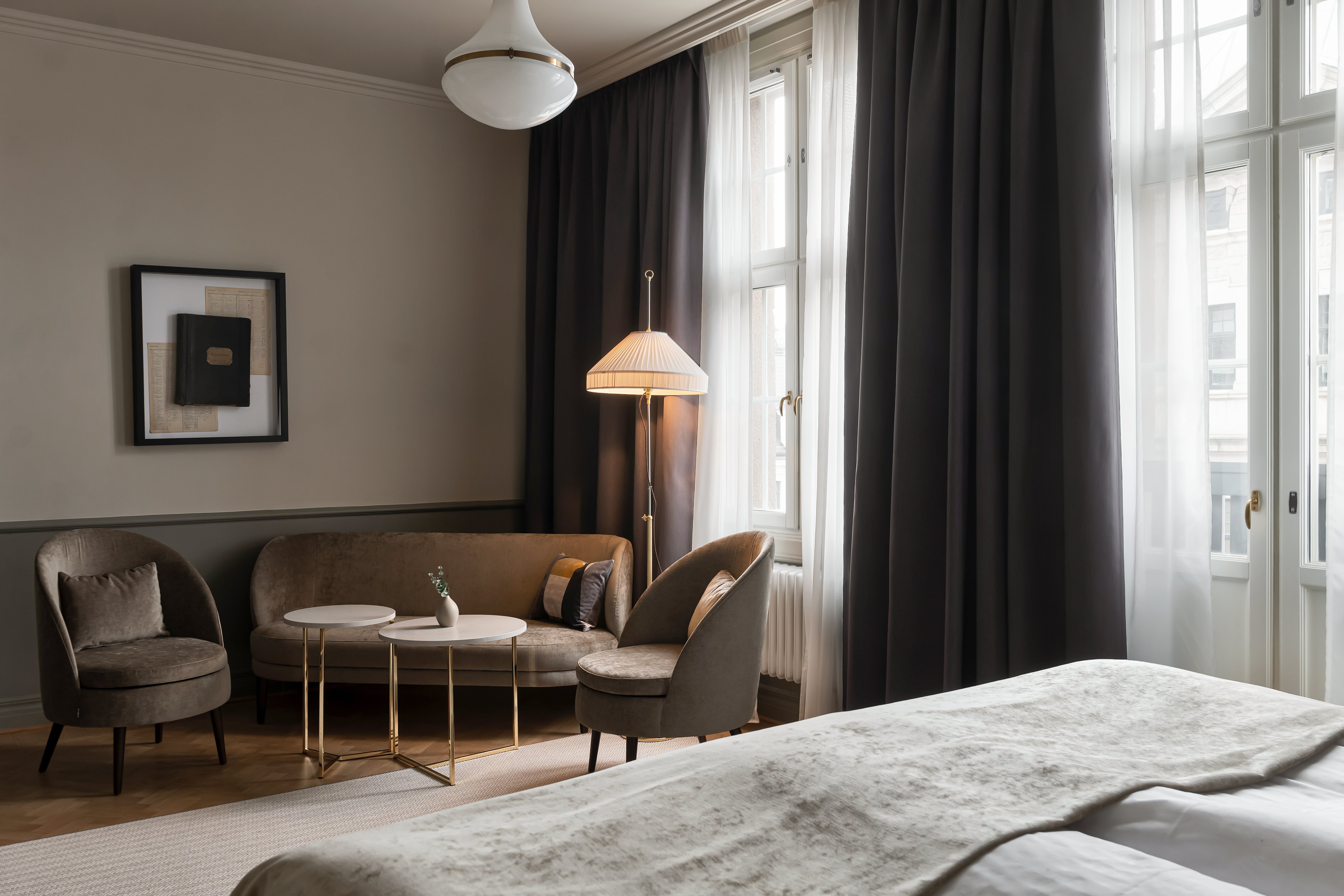 Cozy hotel room with sofa group, floor lamp and curtains