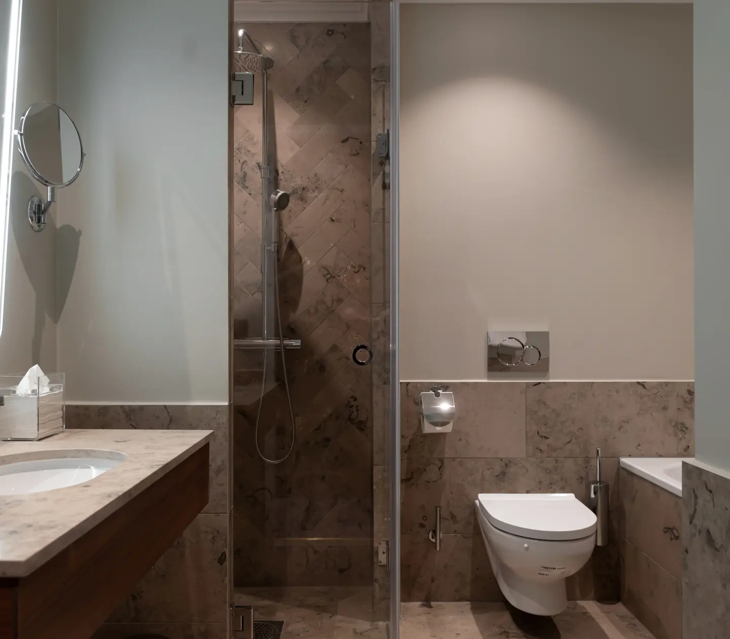 Beige bathroom with toilet, shower and sink