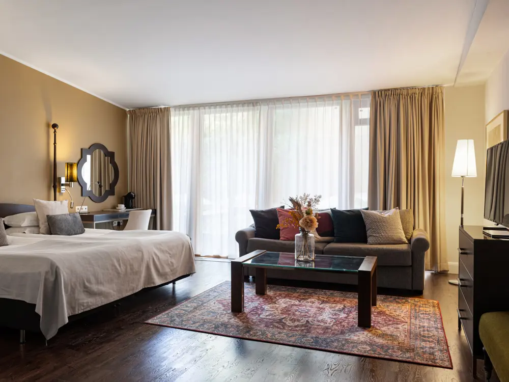 Bright suite with double bed, sofa group and TV