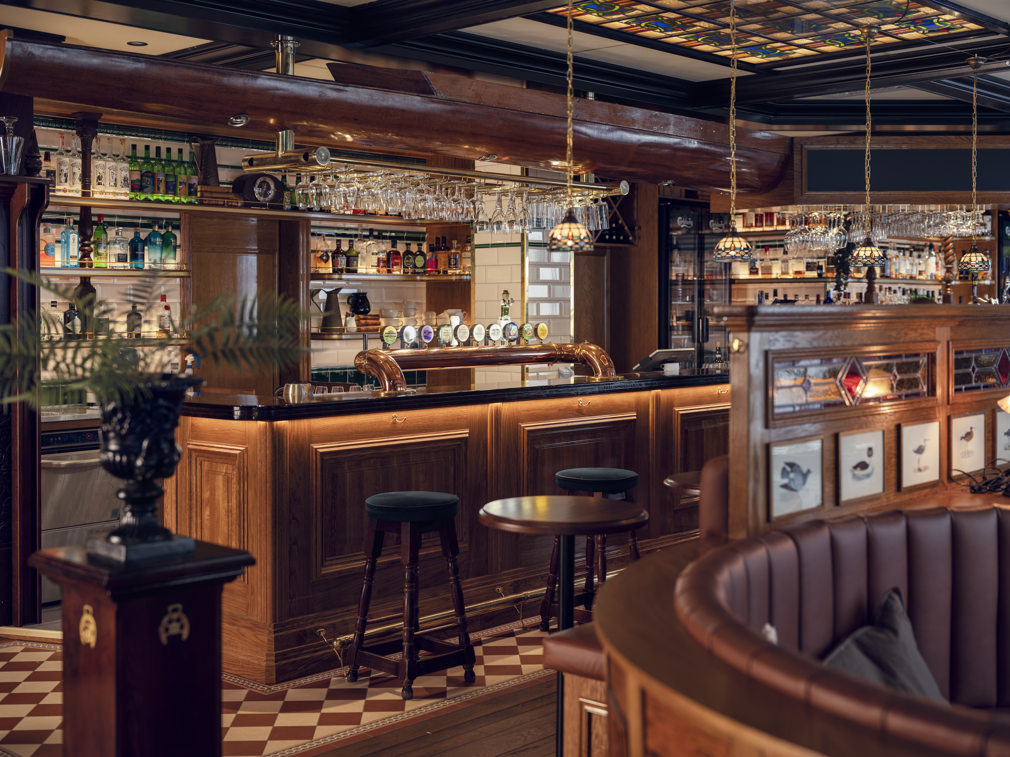 Classic bar interior with wooden counters and stools.