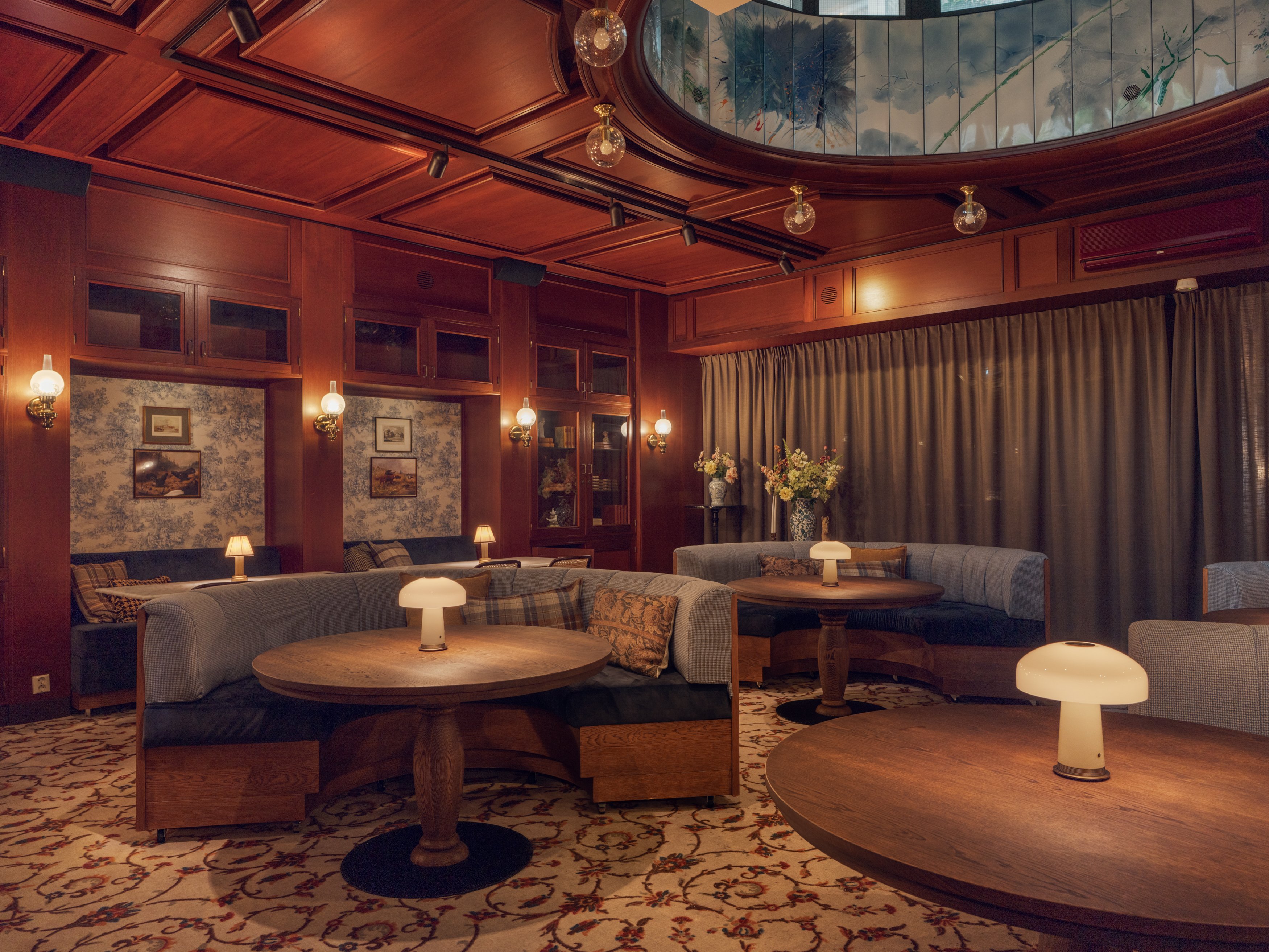 Conference room with elegant wood paneling and comfortable chairs, classic-style decor with a round domed ceiling and bookshelves
