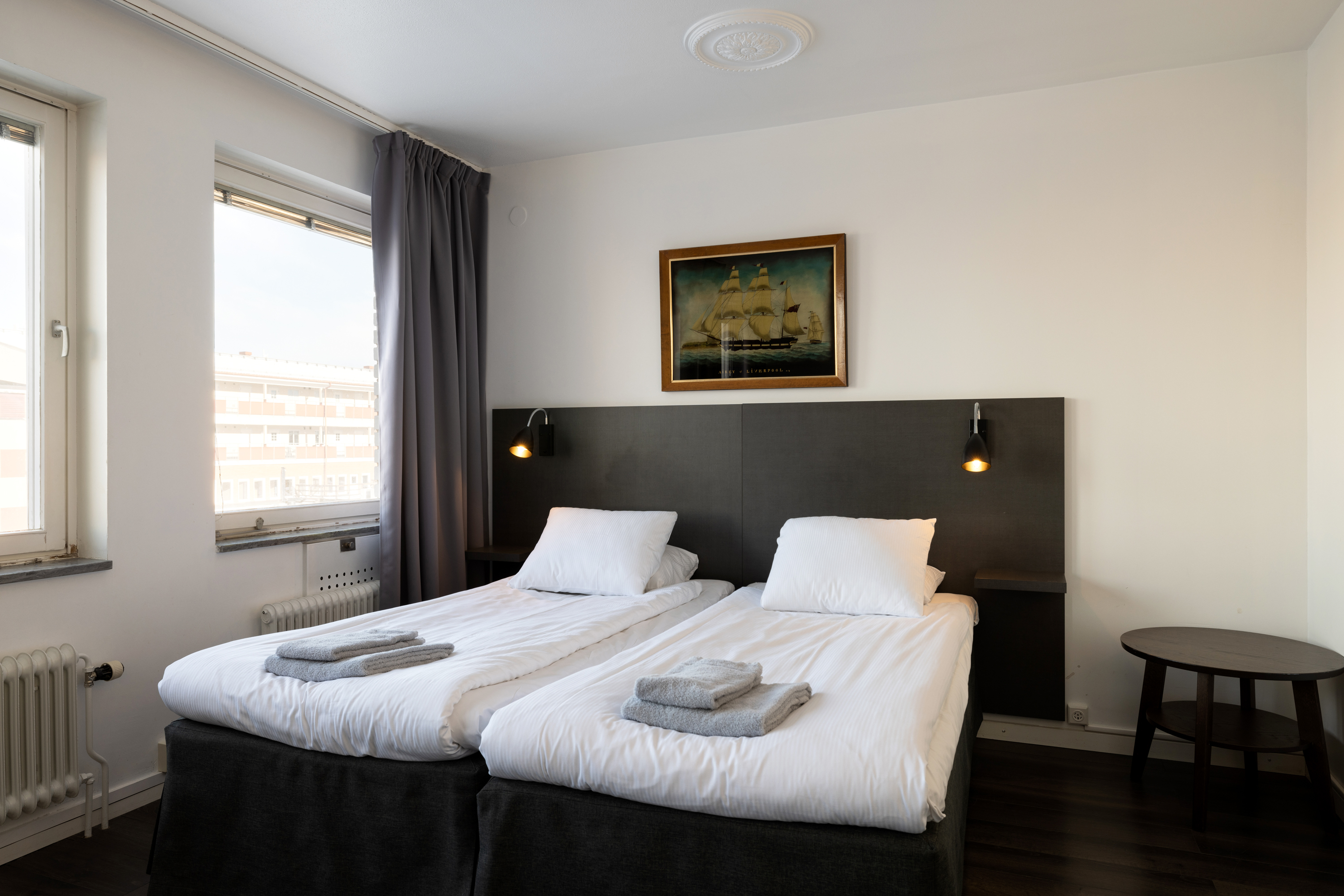 Hotel room with beds, black headboard and blackboard