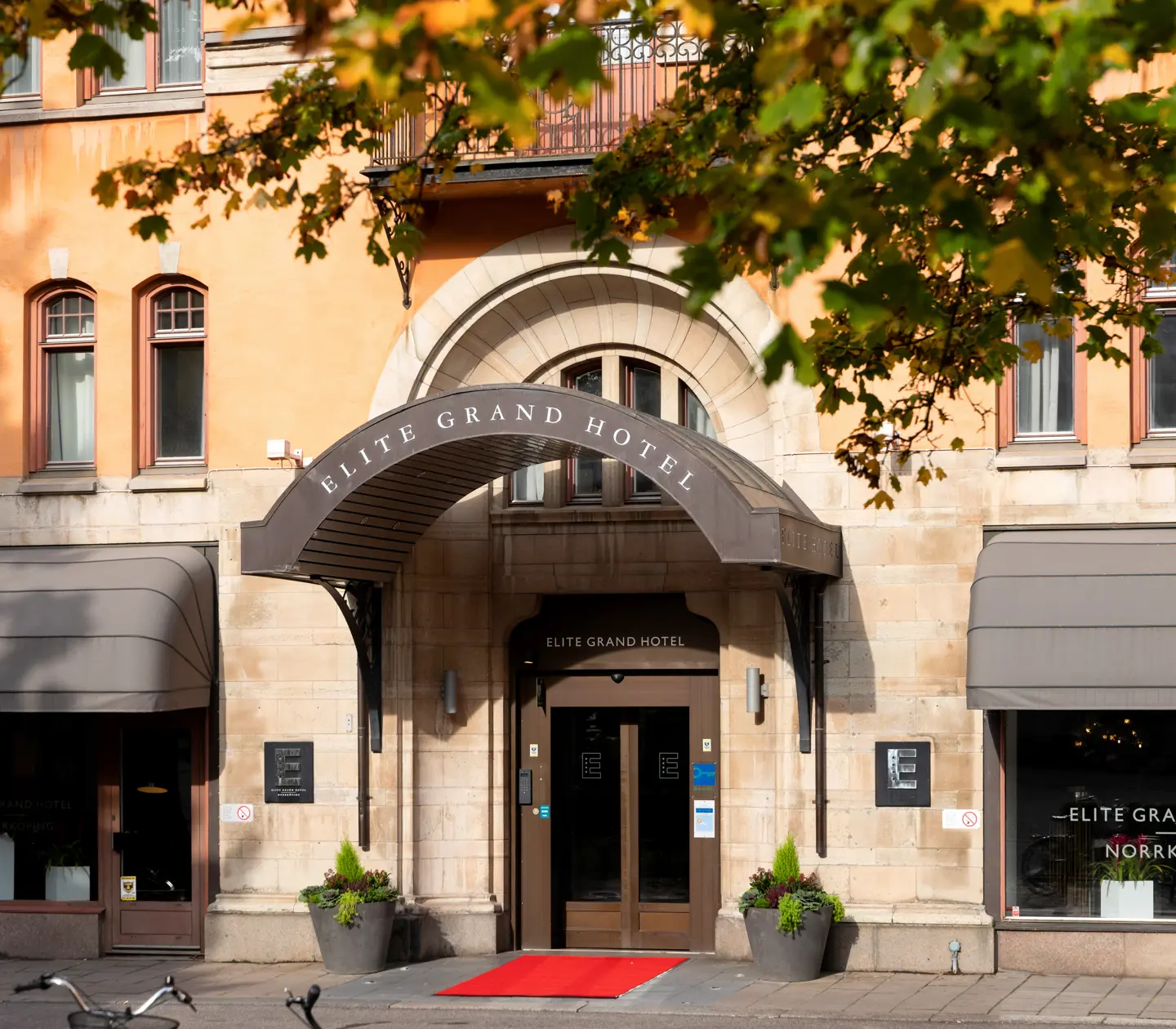 Entrén till Elite Grand Hotel med pampigt tak, röd matta och stora dörrar