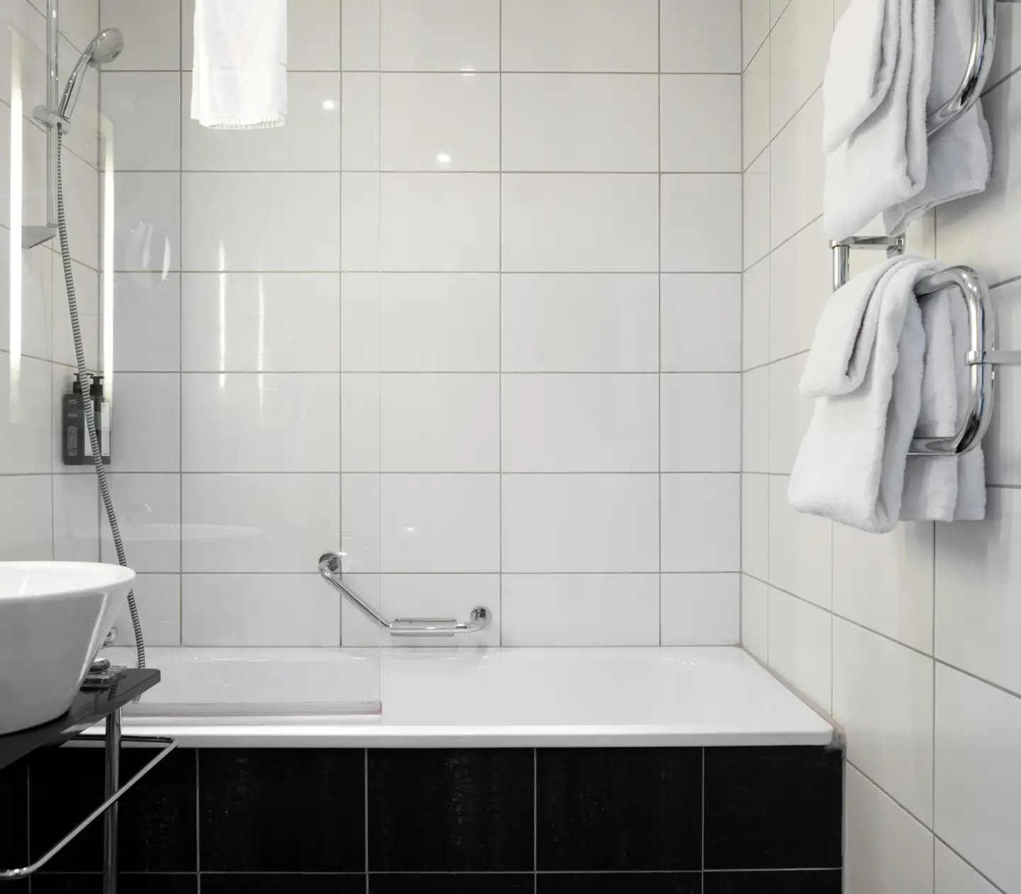 Ljust badrum med handfat, spegel och badkar