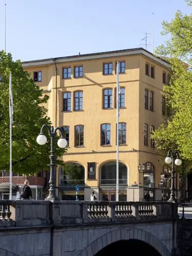 En gul byggnad som speglas i vattnet intill