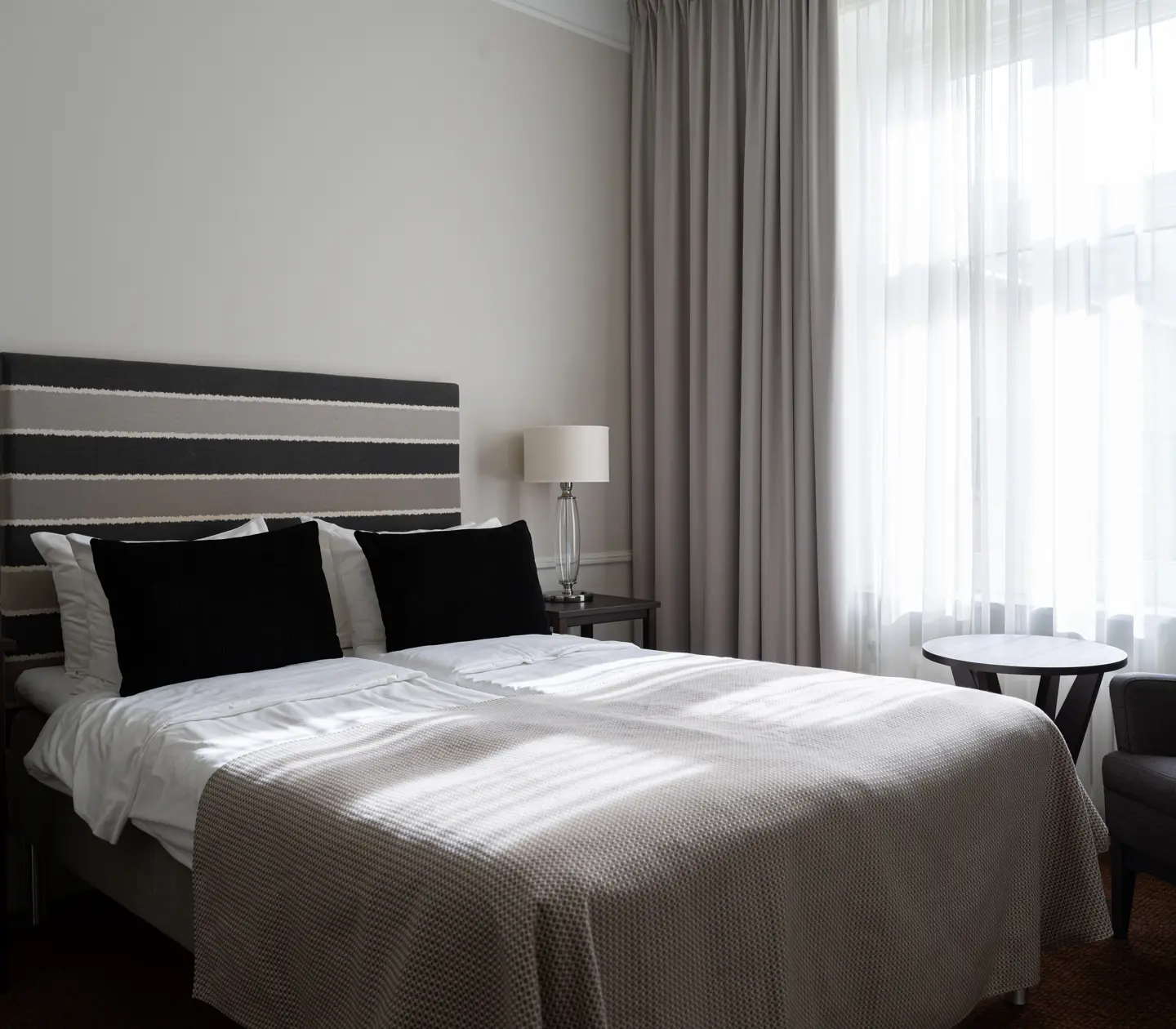 Hotel room with double bed, armchair and window