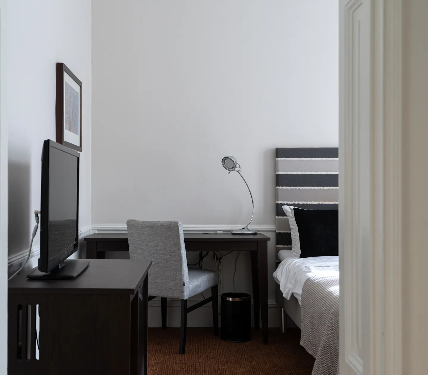 Hotel room with part of bed, armchair, wardrobe and window