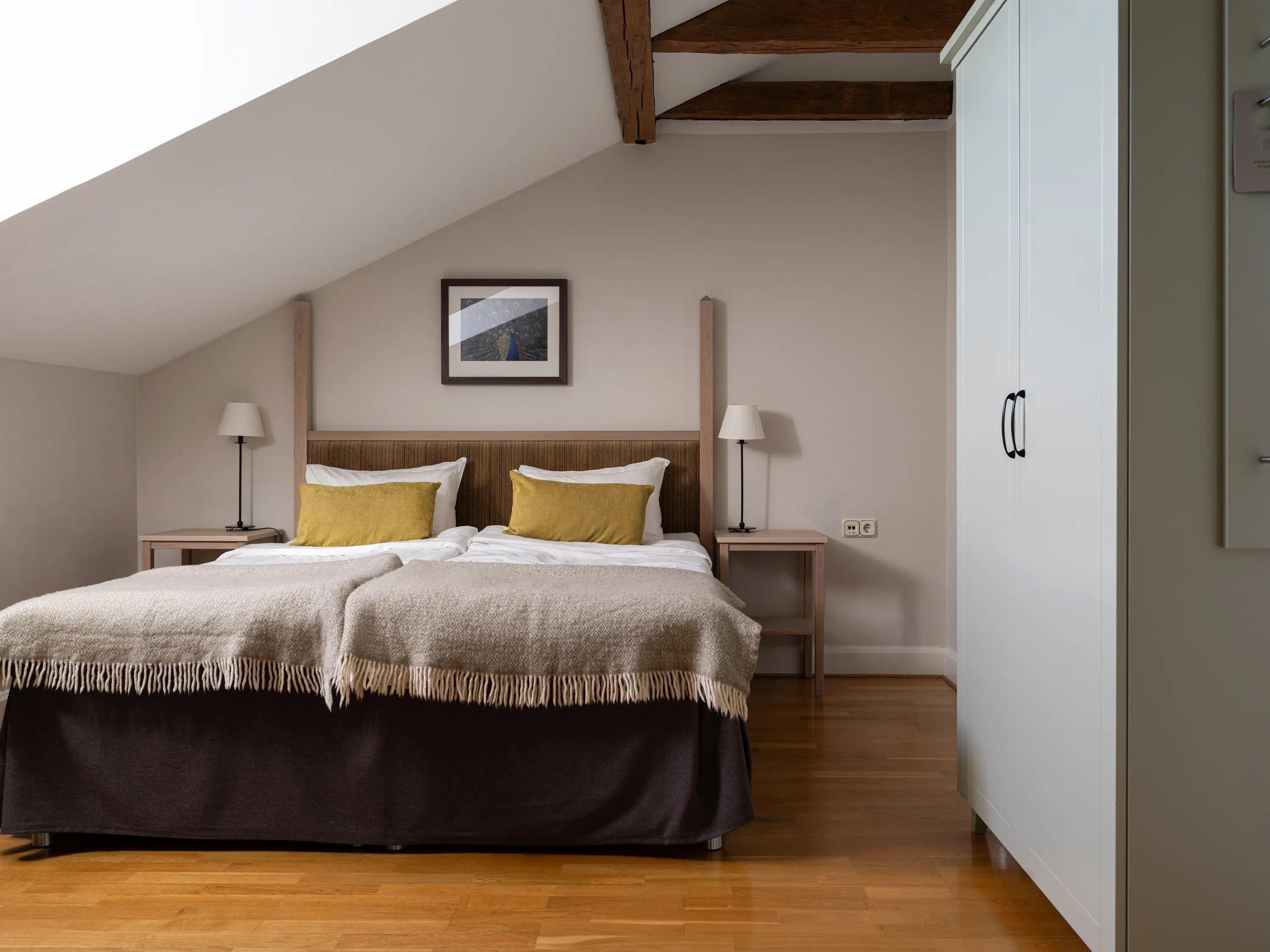 Hotellrum med dubbelsäng, fåtölj och fönster