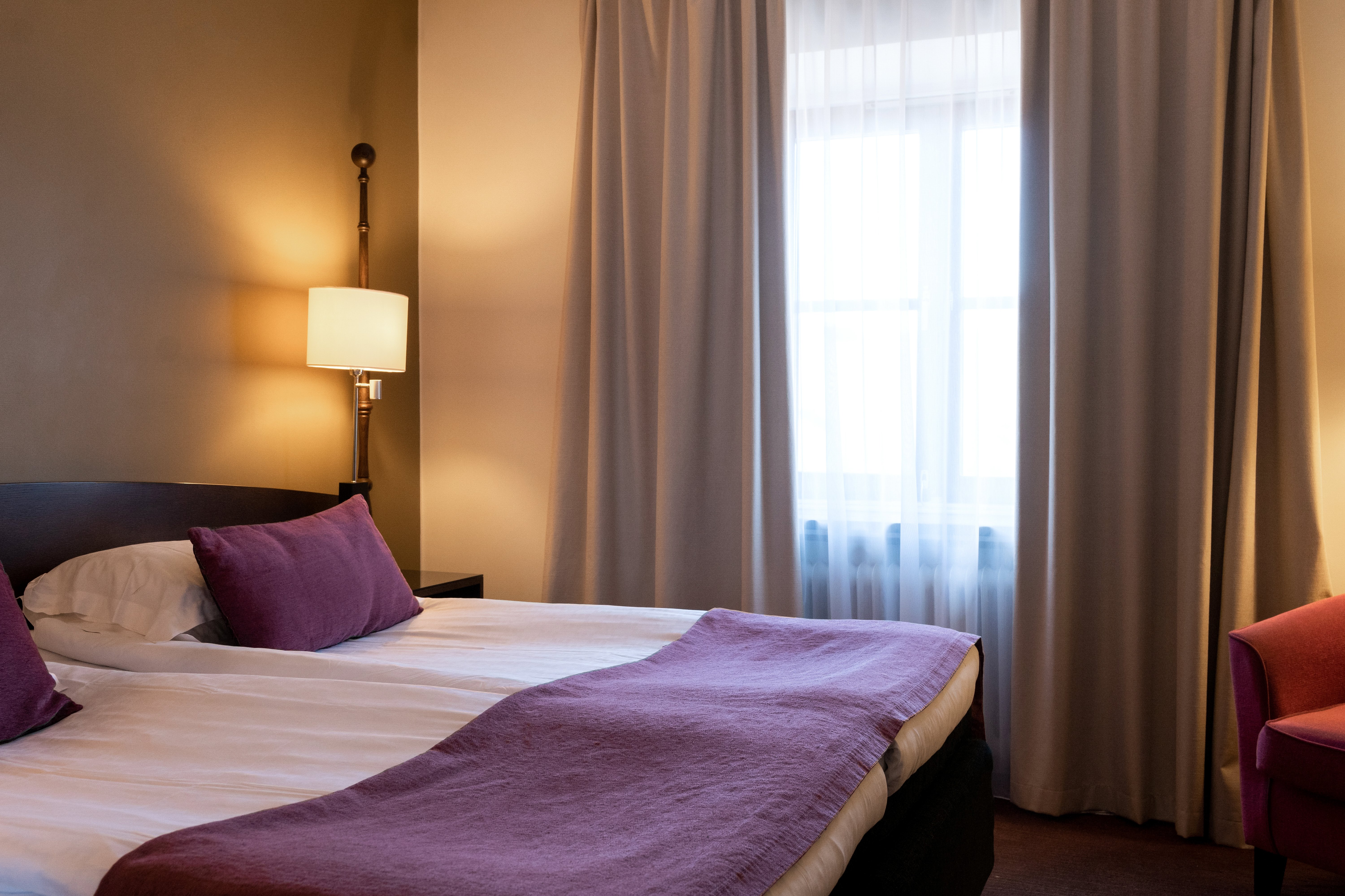 Hotel room with double bed, armchair and window