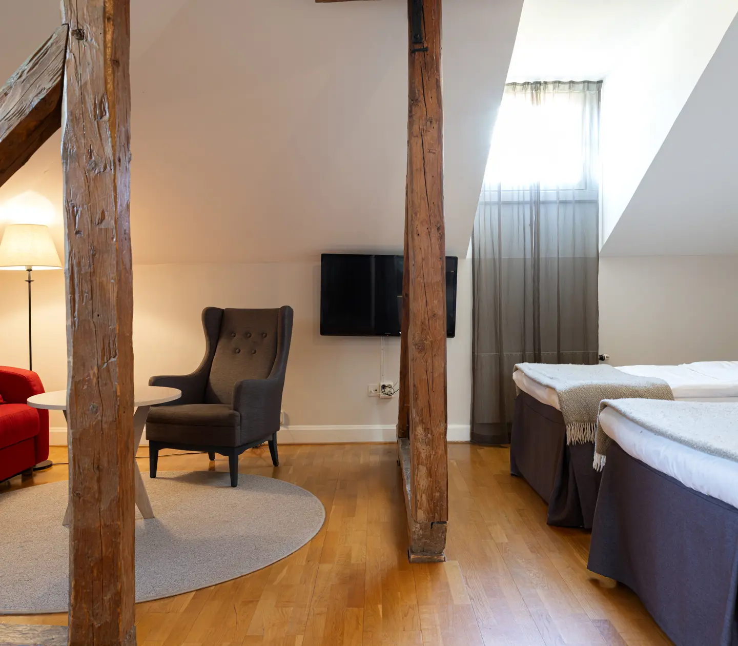Bright hotel room with double bed, armchairs and window