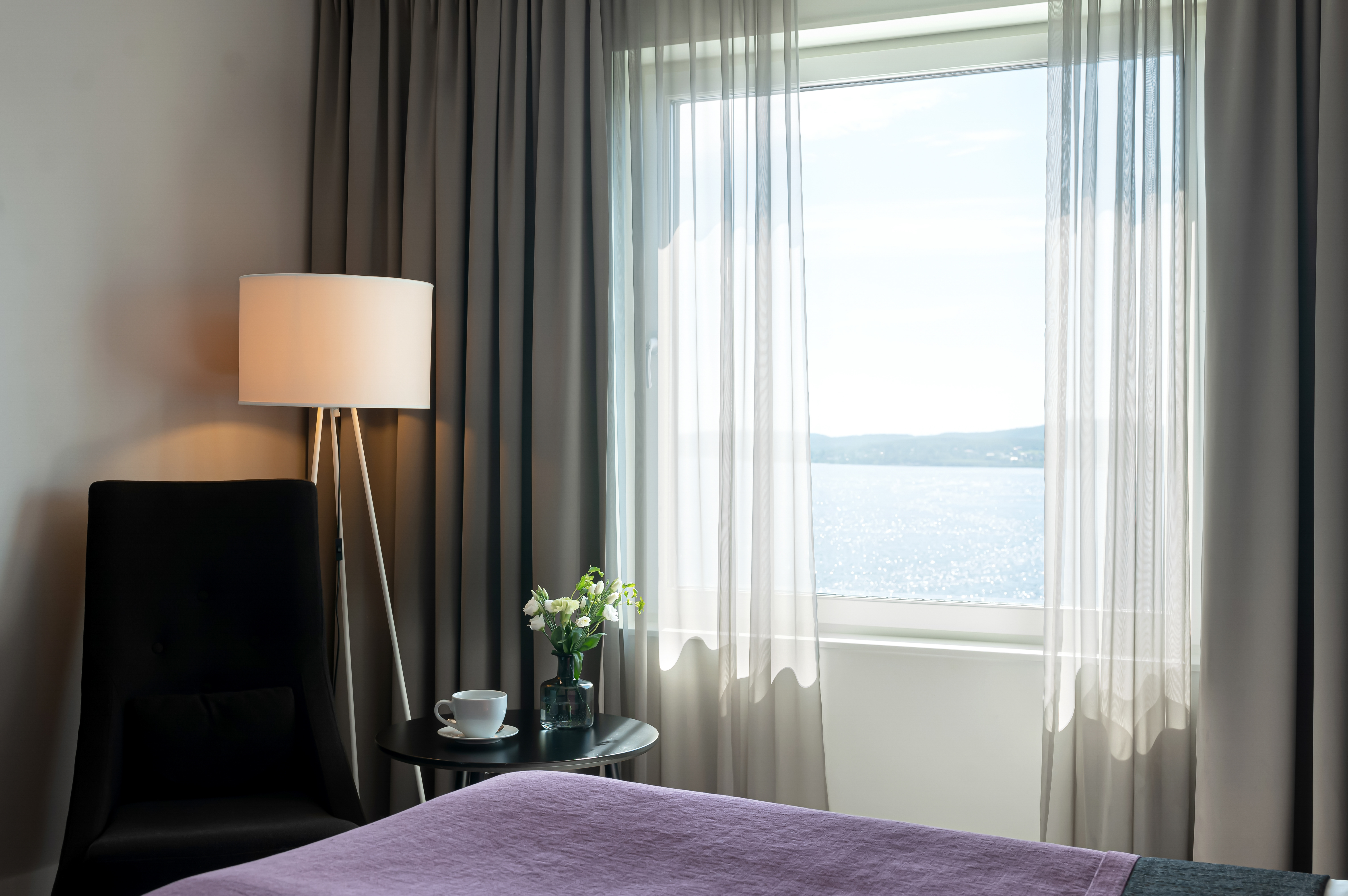 Hotel room with bed, armchair and sea view