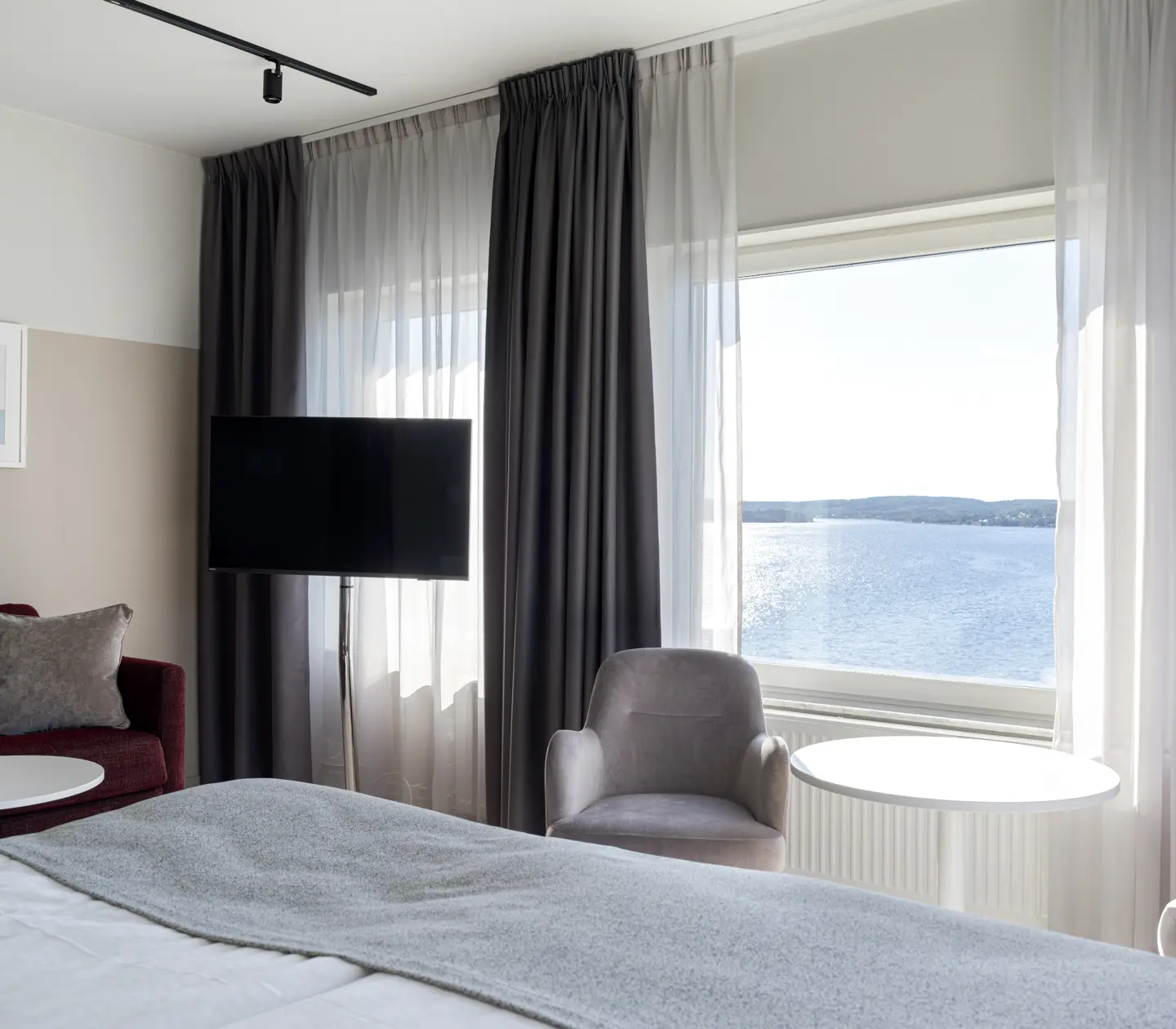 Hotellrum med tv, fåtöljer och fönster
