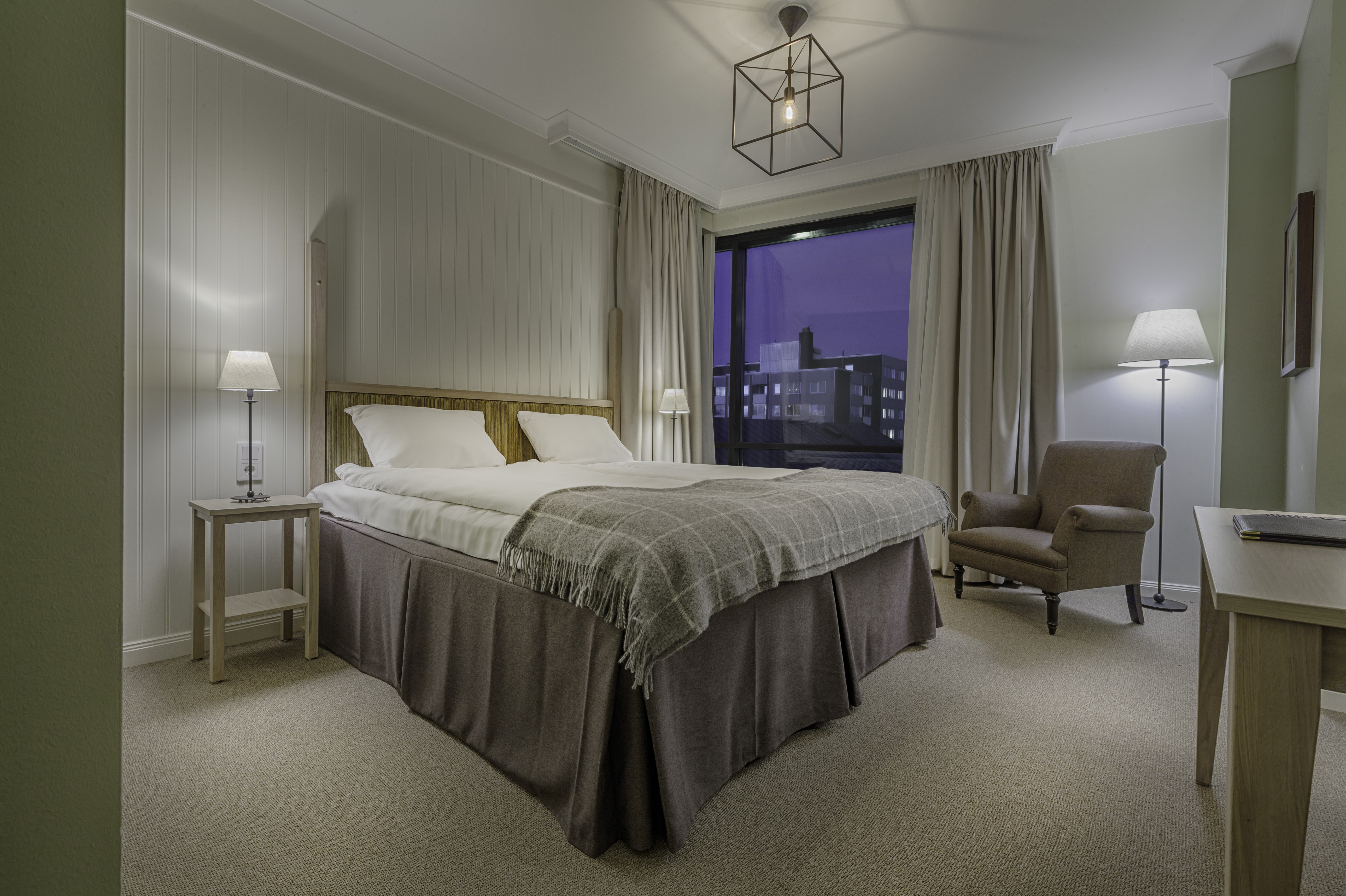 Cozy hotel room with bed, armchair and window