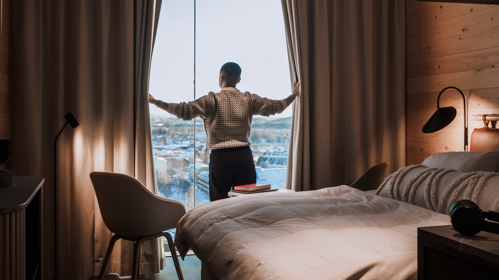 Person vid fönstret i ett hotellrum på The Wood Hotel by Elite