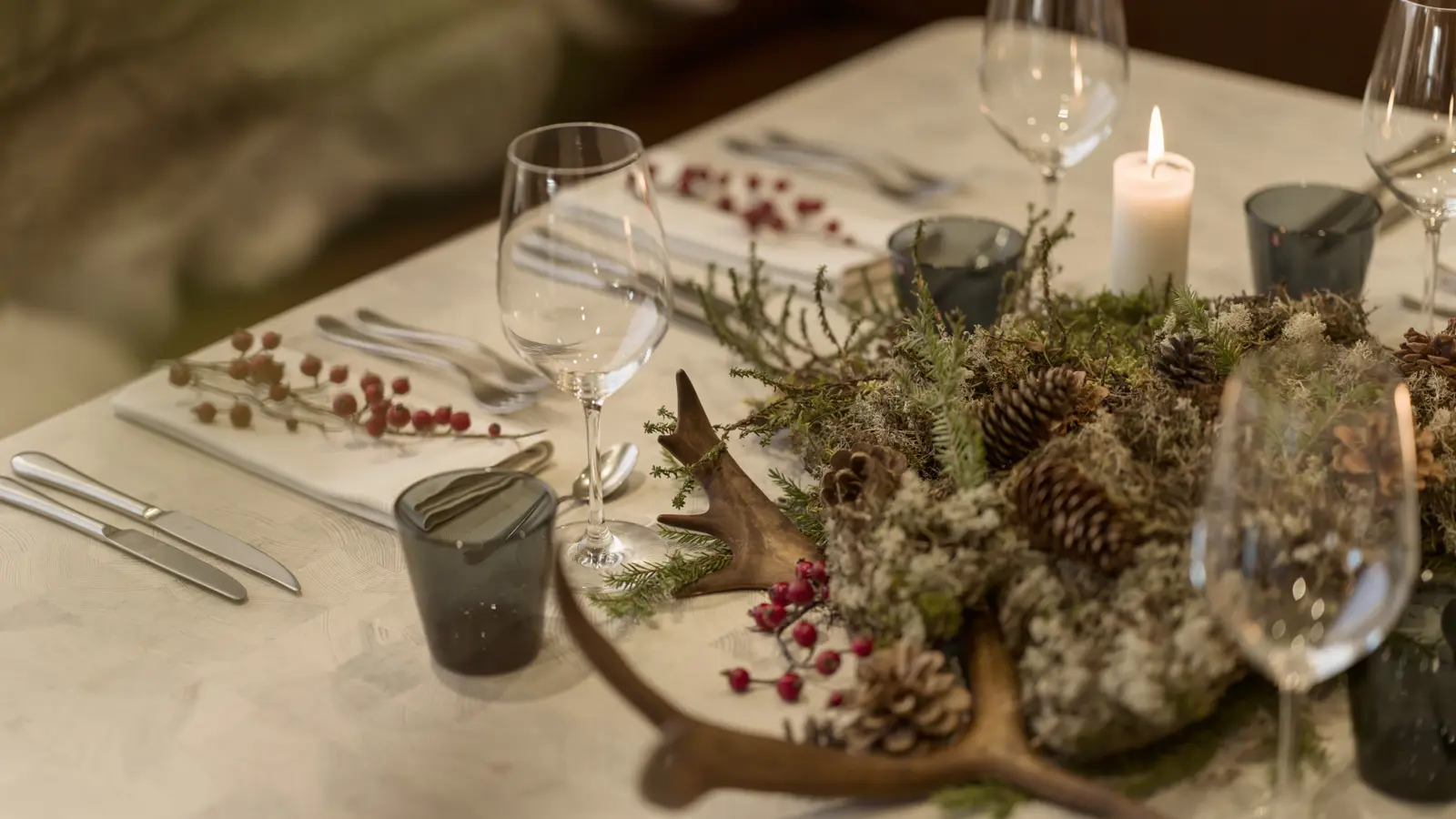 Image of a plate, wine glasses, cutlery and napkin on a dining table