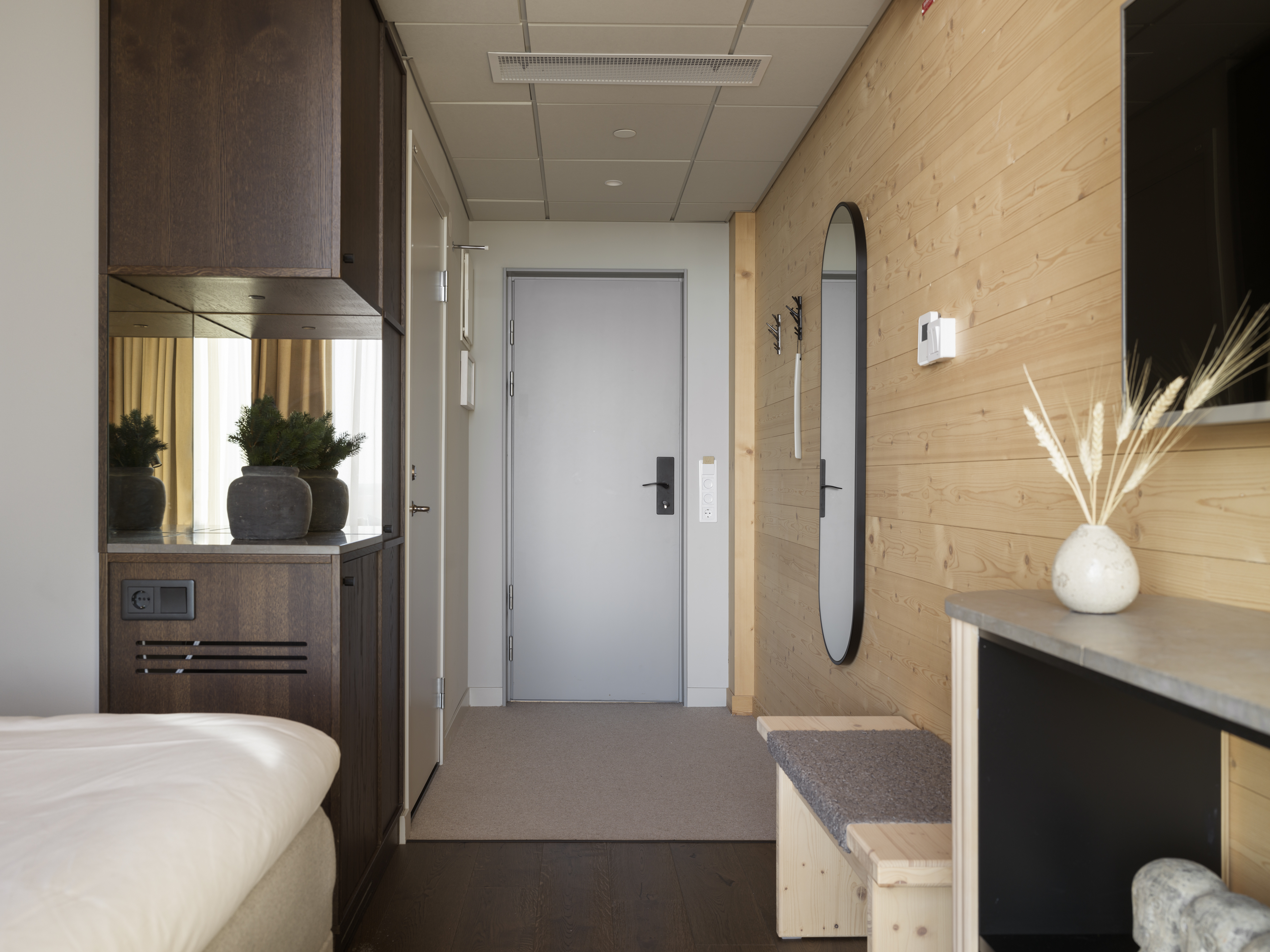 Hotellrum med säng, tv och stort fönster med utsikt över Skellefteå