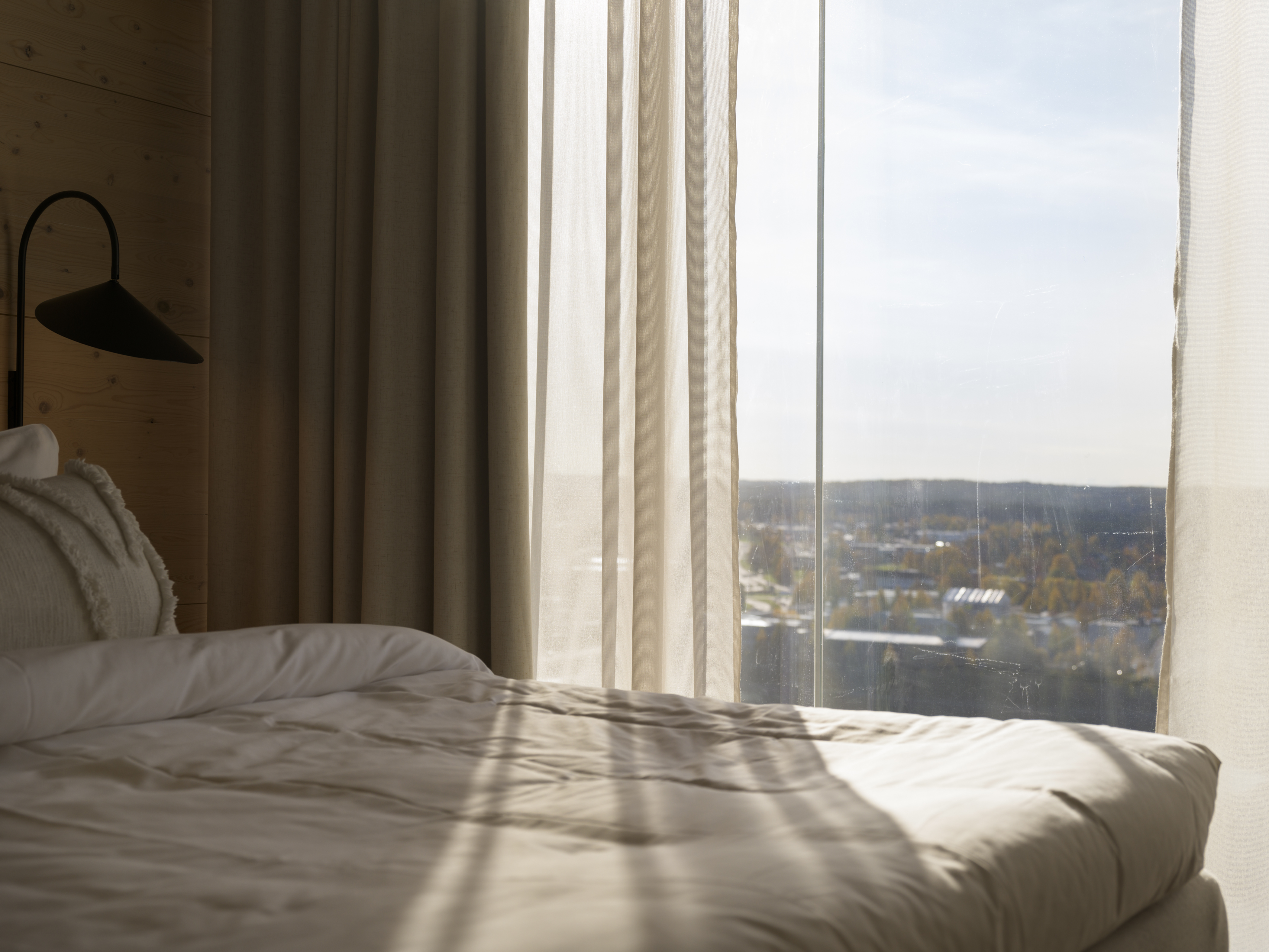 Mysigt hotellrum med säng, tv och spegel