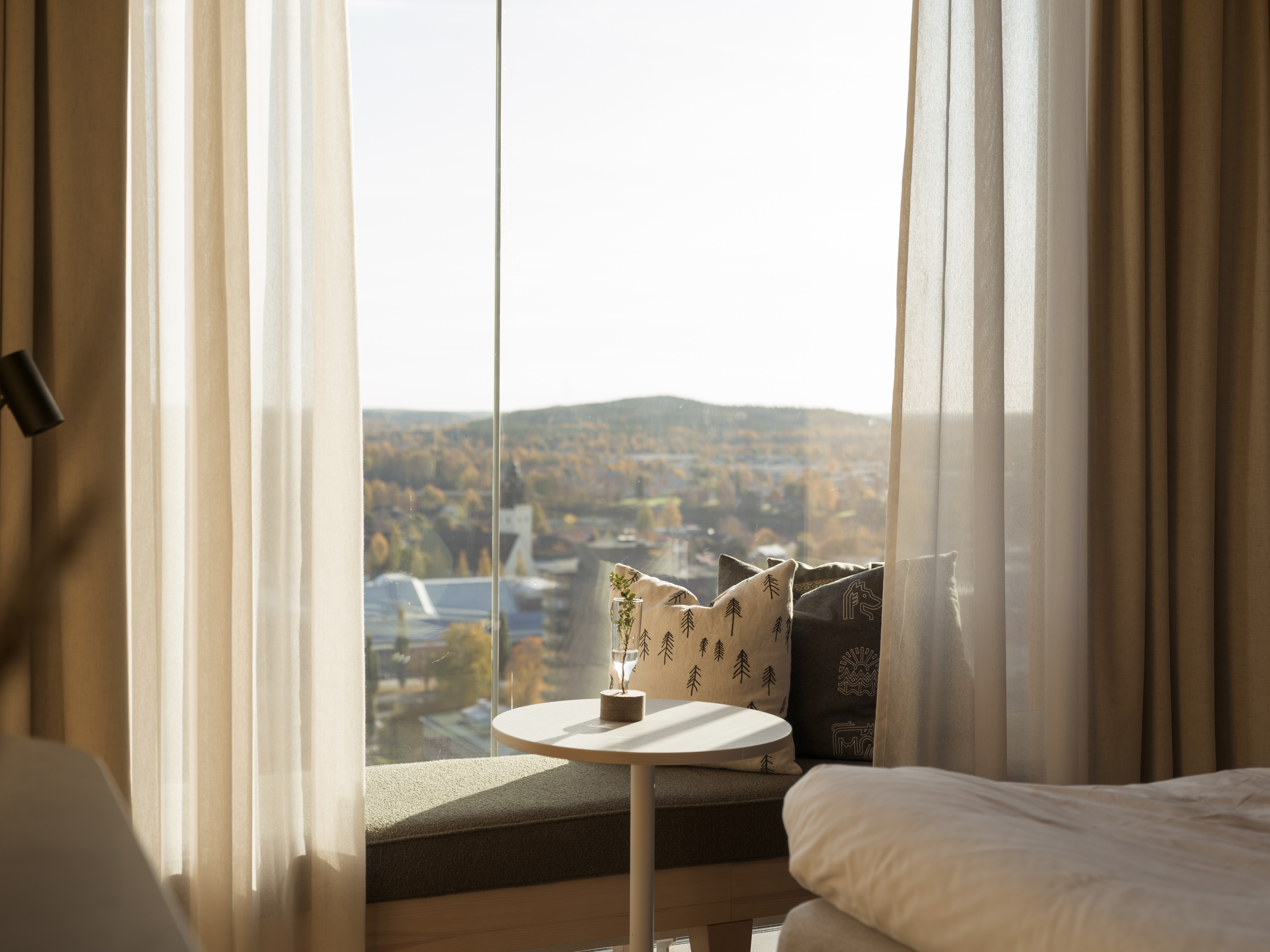 Mysigt hotellrum med säng, tv och spegel