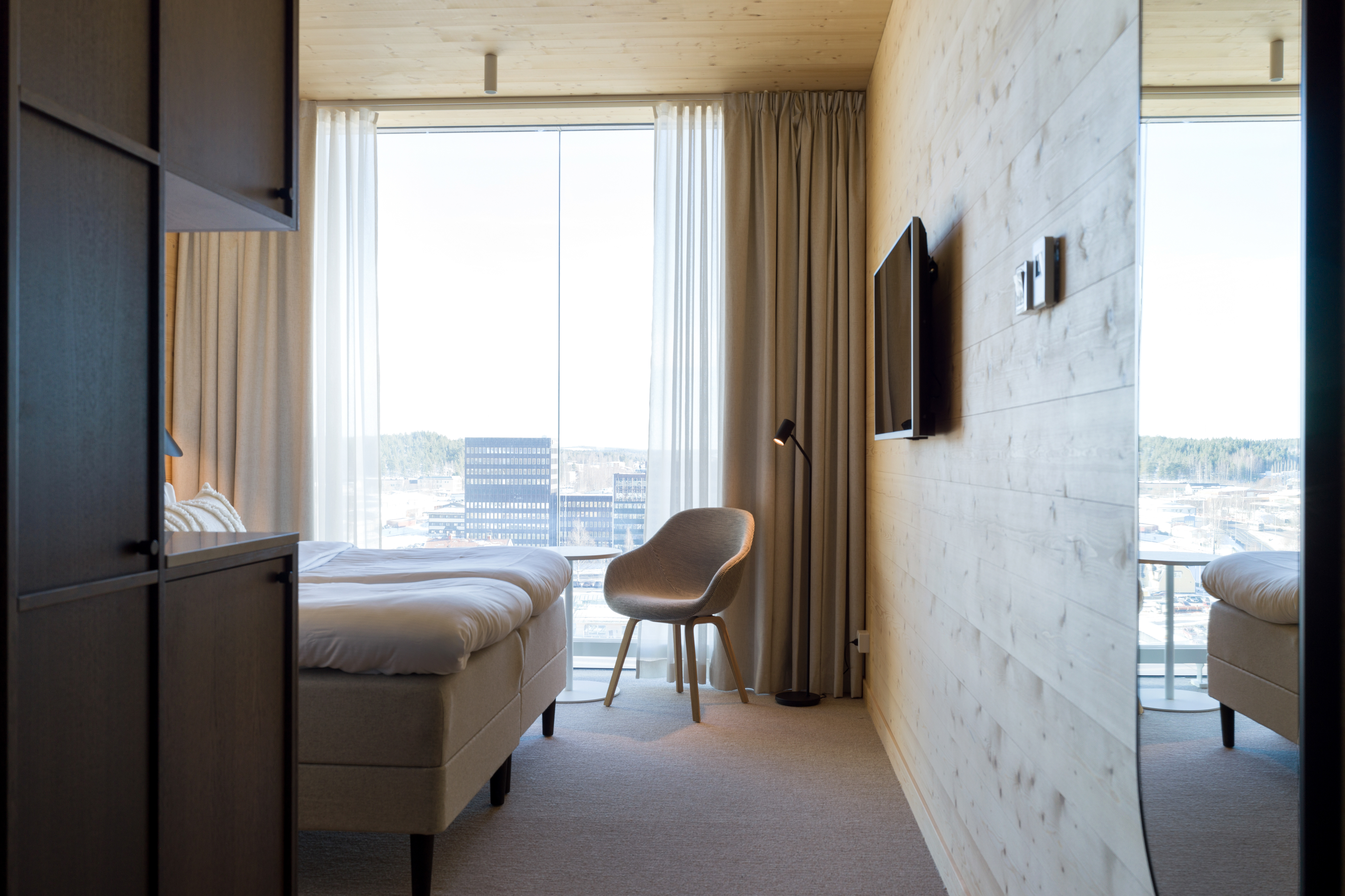 Cozy hotel room with bed, armchair and large window