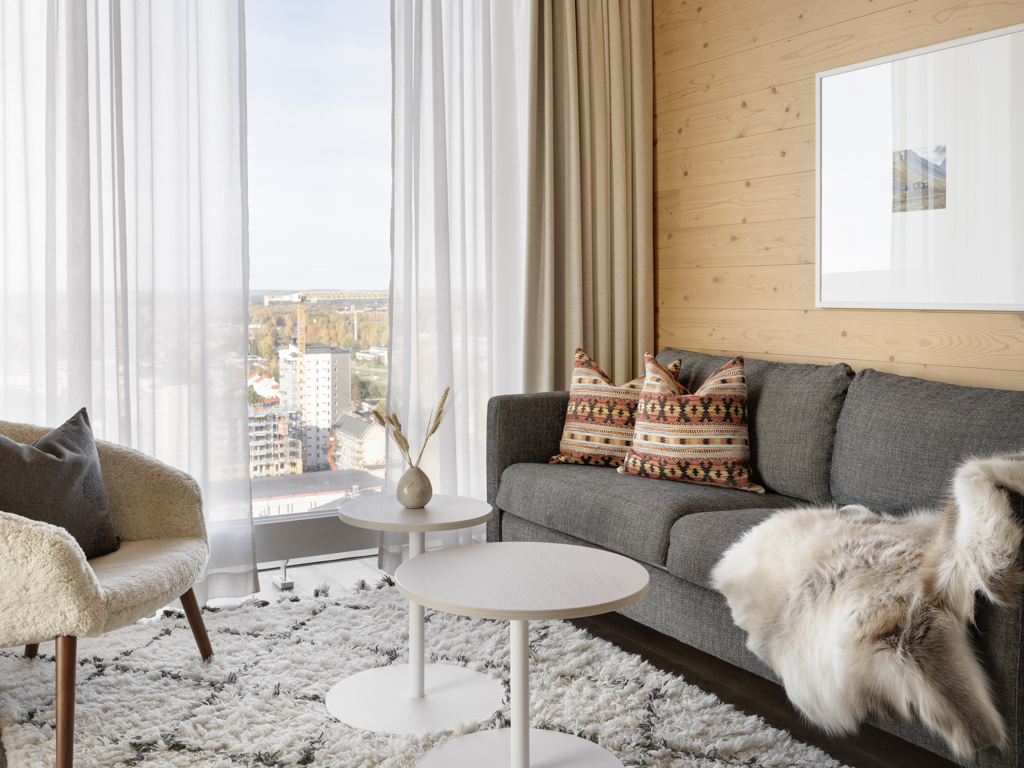 Mysigt hotellrum med säng, fåtölj och stort fönster