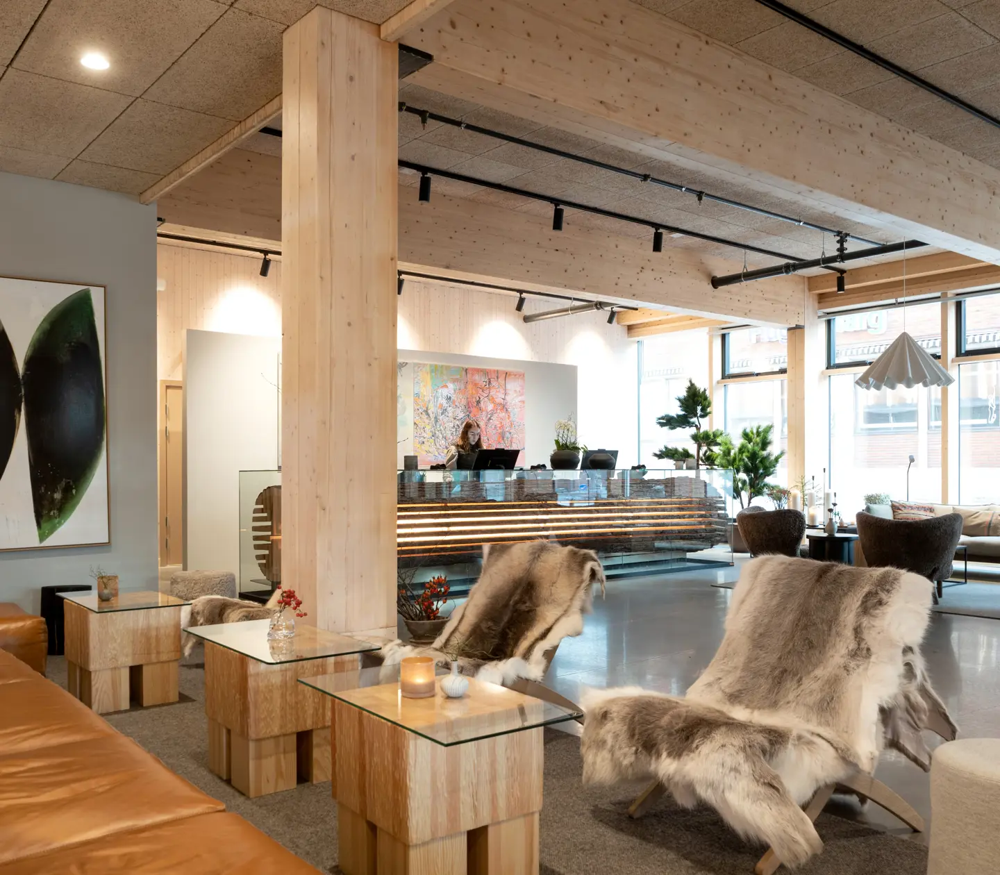 Welcoming hotel lobby with reception desk, lounge furniture and sheepskin traps