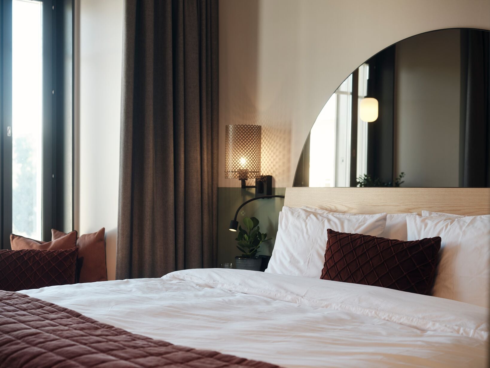 Mysigt hotellrum med säng, fåtölj och stort fönster