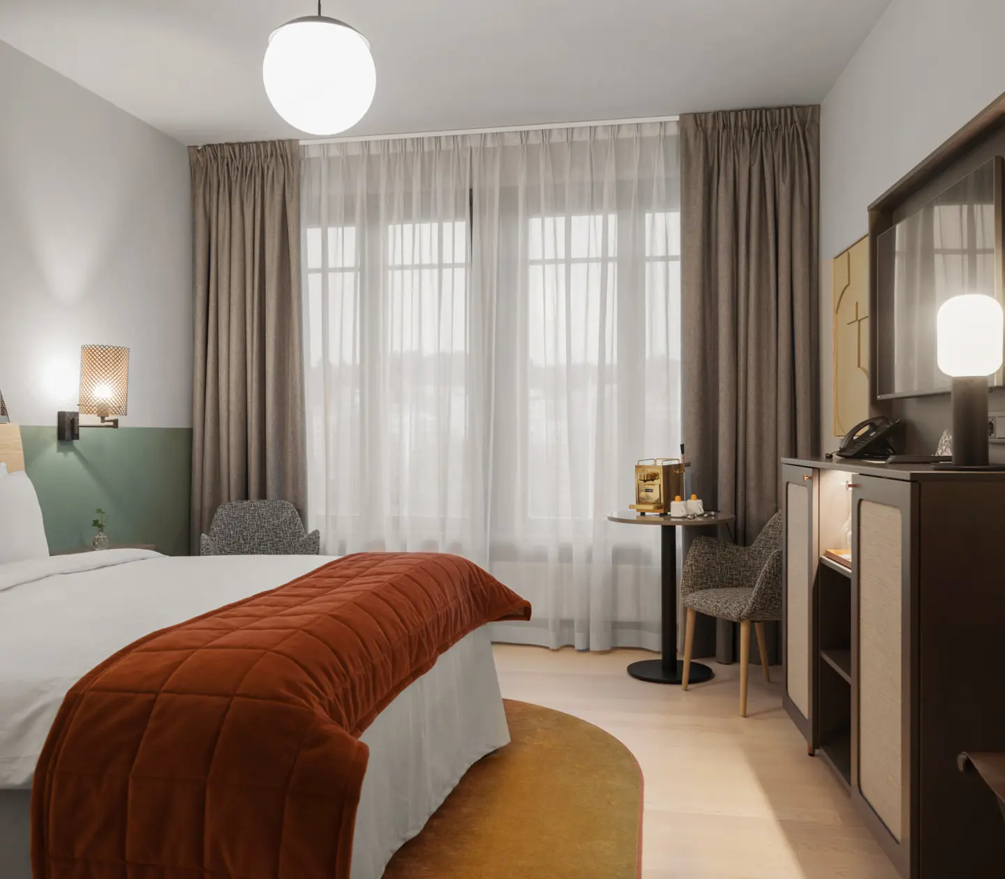 Mysigt hotellrum med säng, fåtölj och stort fönster