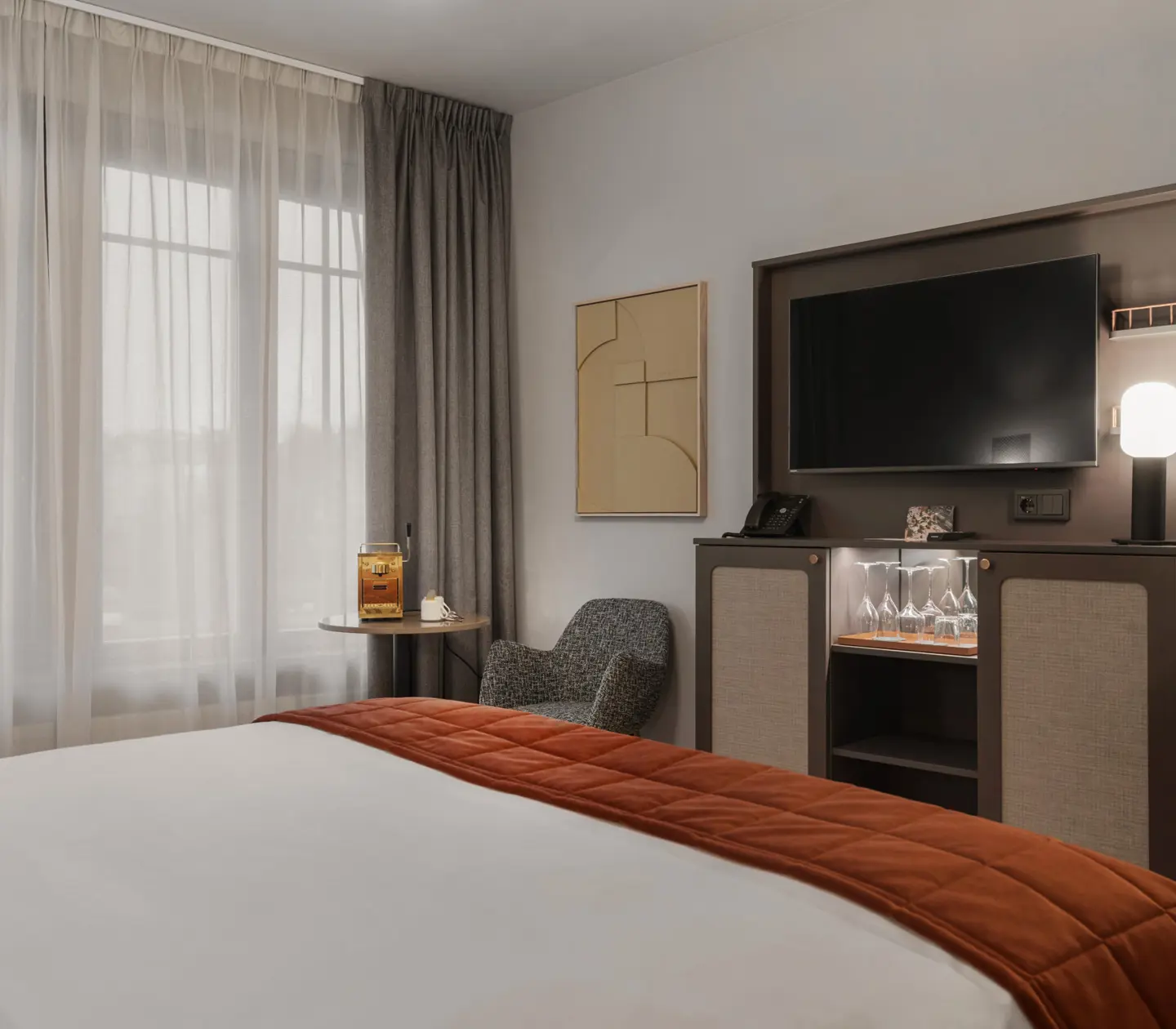 Mysigt hotellrum med säng, tv och stort fönster