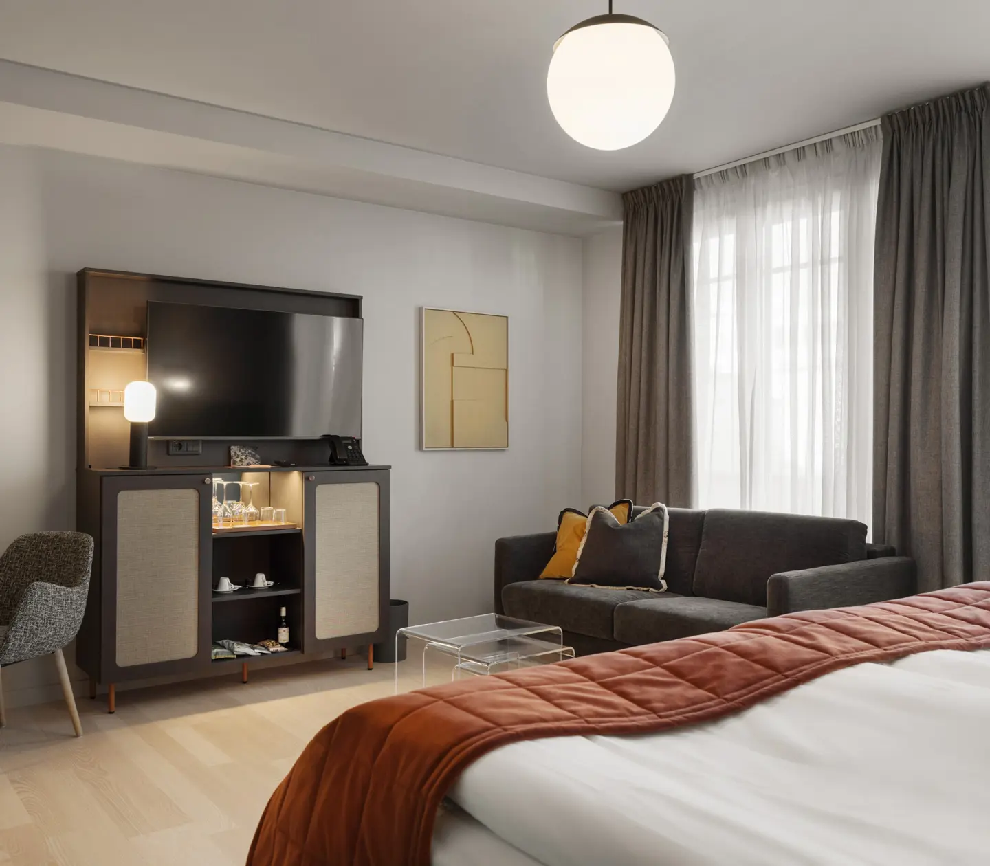 Mysigt hotellrum med säng, soffa och tv