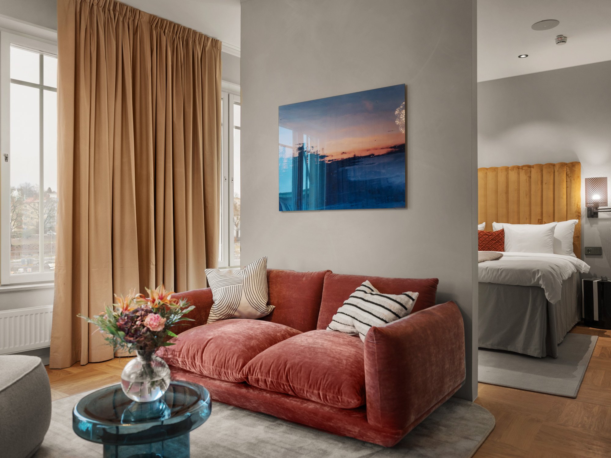 Cozy suite with bed, yellow headboard and pink sofa