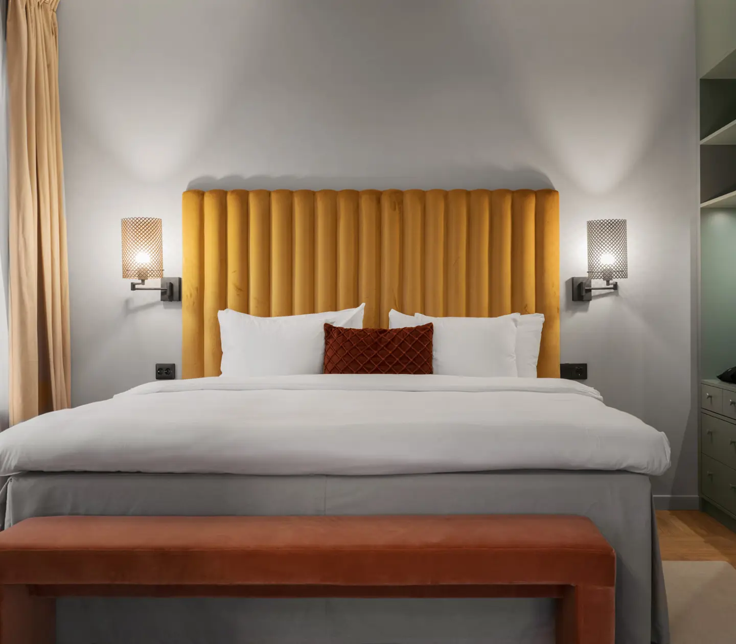 Suite with sofa, yellow headboard and bedside lamps