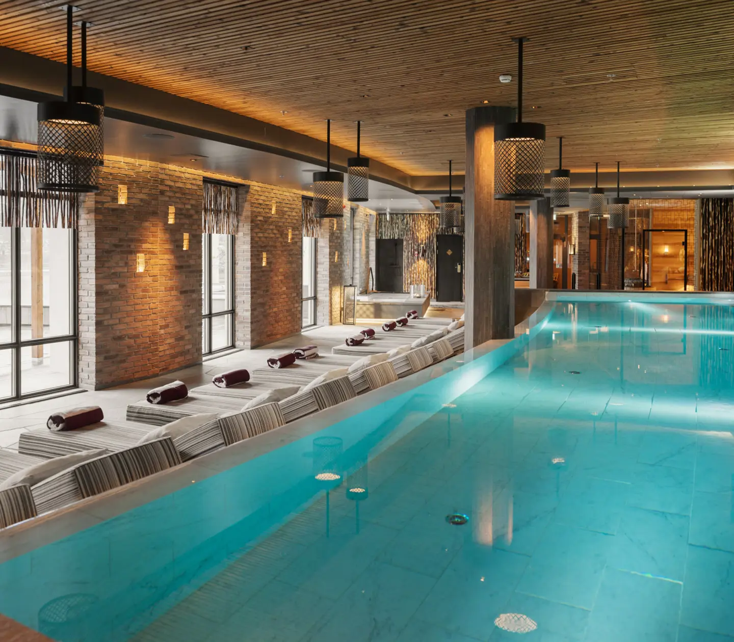 Spa environment with large pool, many sunbeds and large windows