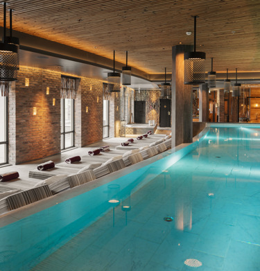Spa environment with large pool, many sunbeds and large windows
