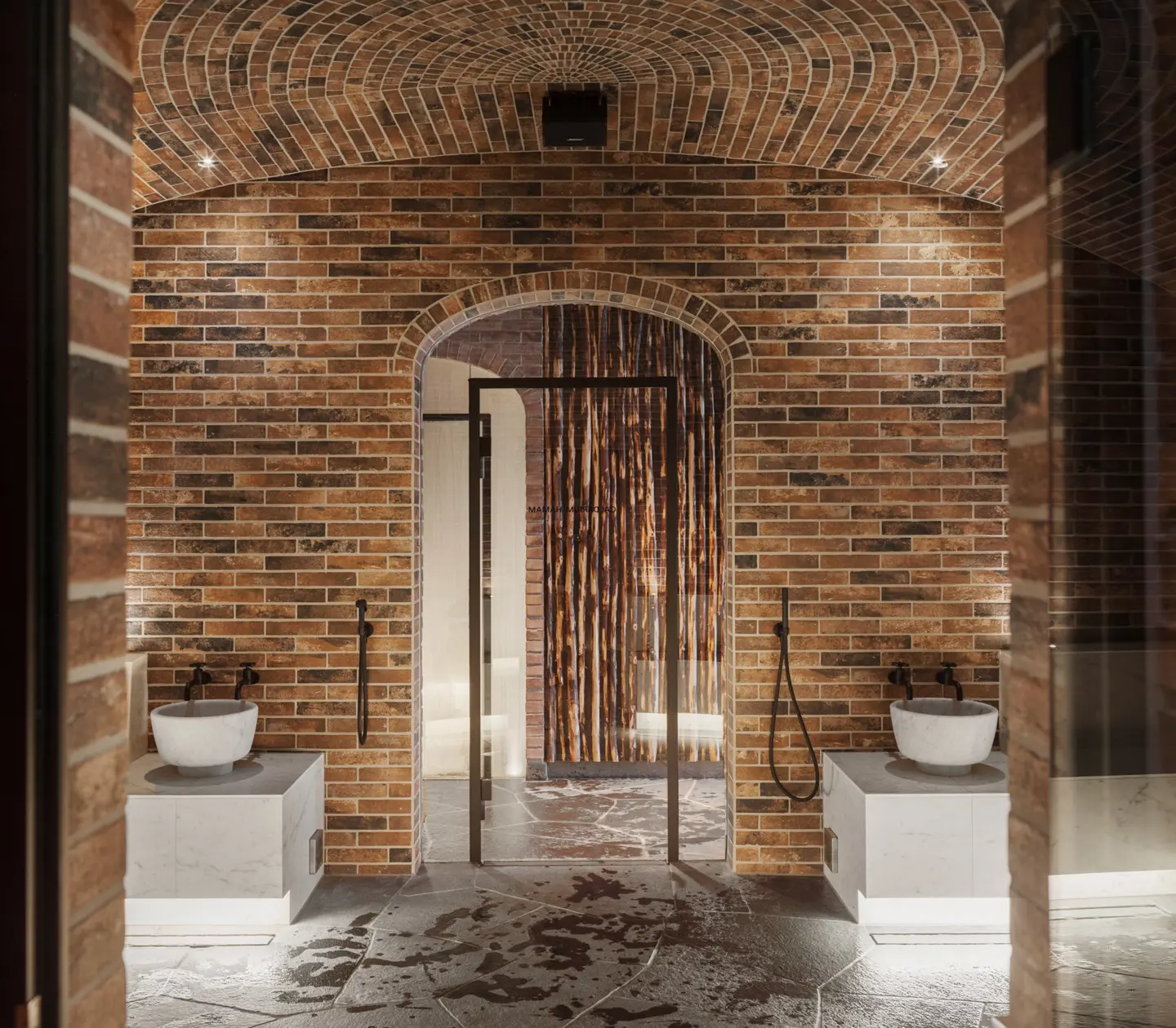 Spa environment with sinks, showers and brick ceiling and walls
