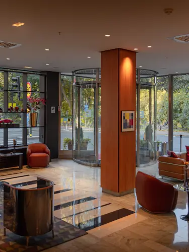 Hotellobby med loungemöbler och grönska utanför