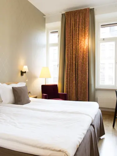Fint hotellrum med säng, skrivbord och fönster